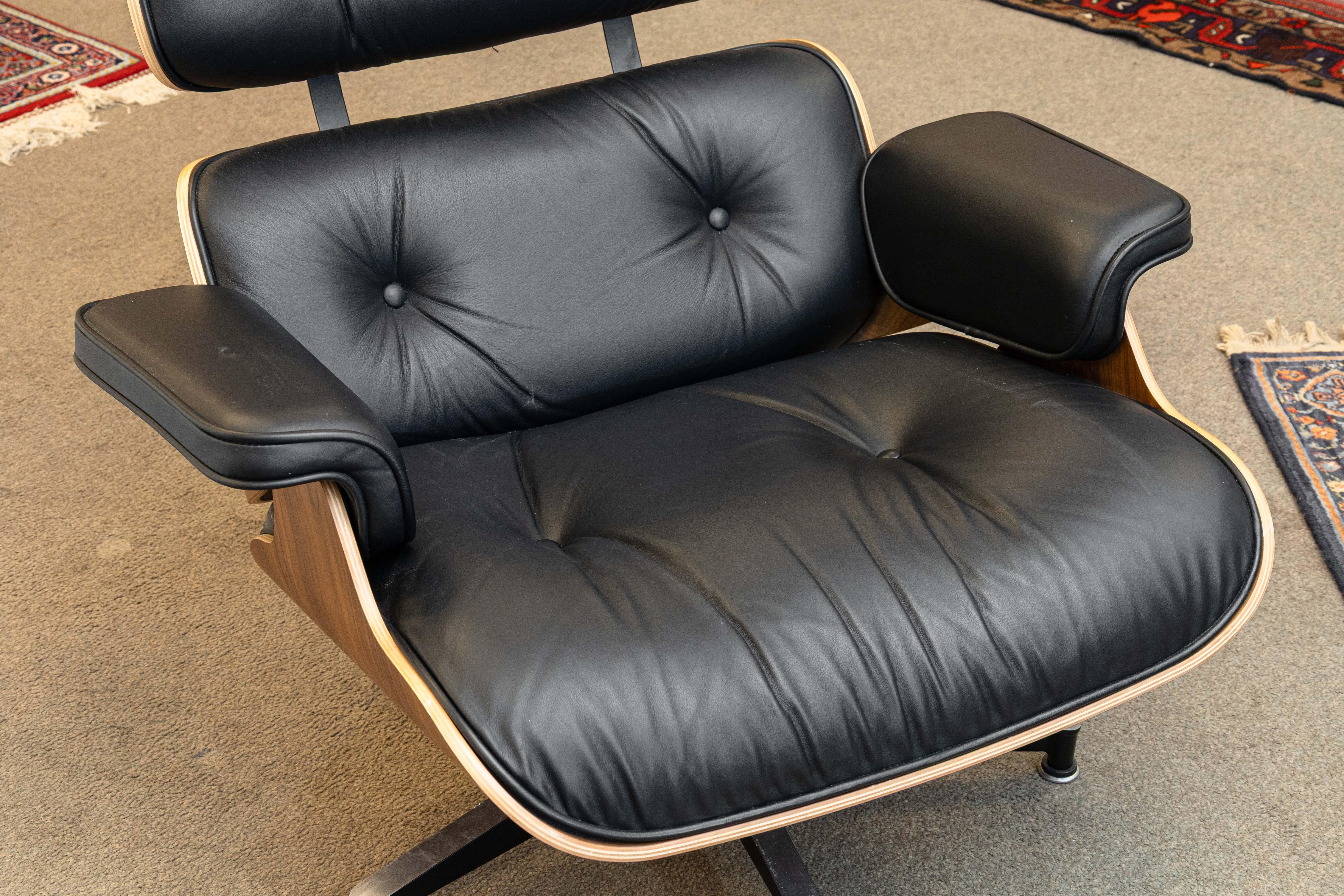 Eames para Herman Miller Silla de salón y otomana de cuero negro y nogal Moderno de mediados de siglo