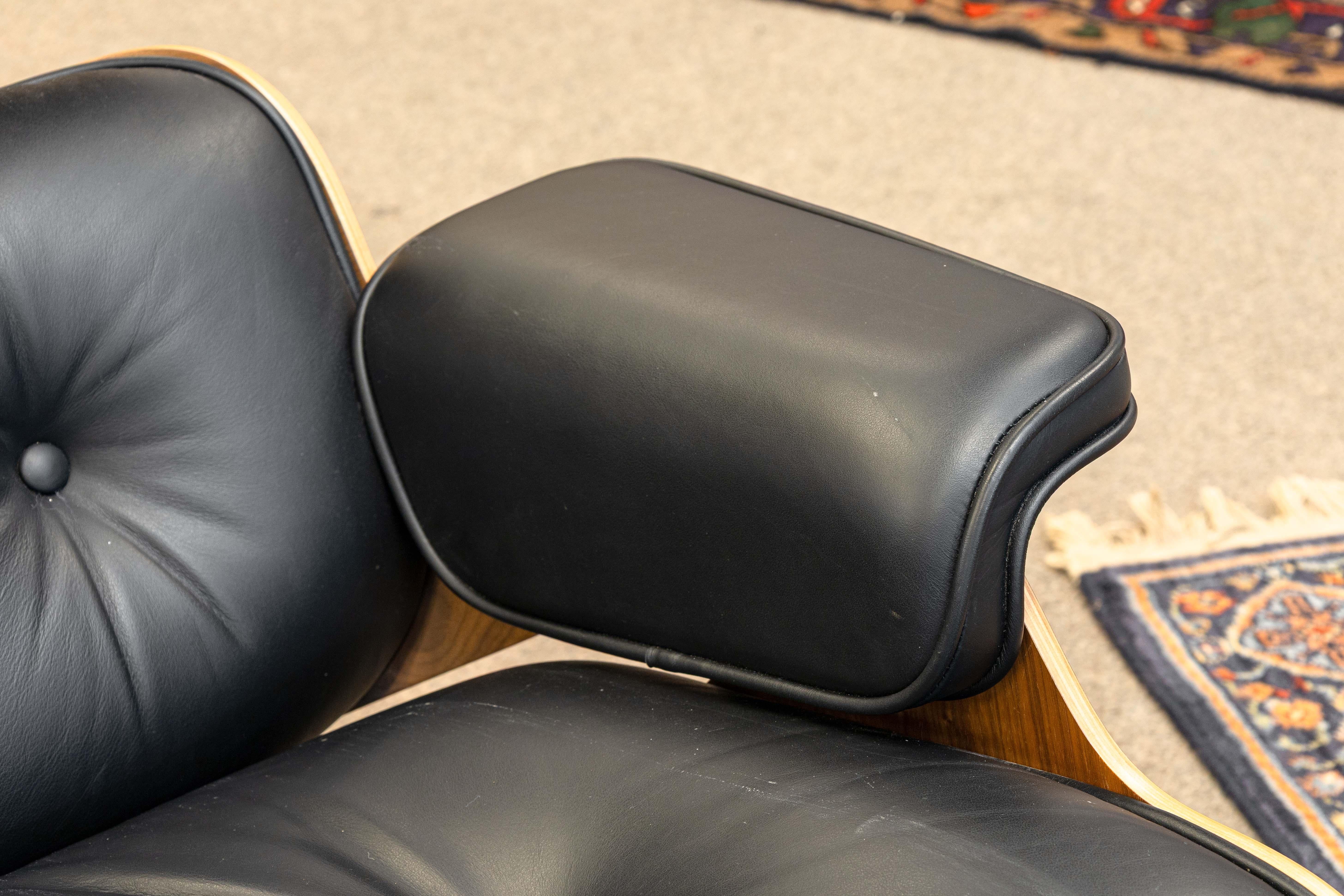 Eames para Herman Miller Silla de salón y otomana de cuero negro y nogal Estadounidense