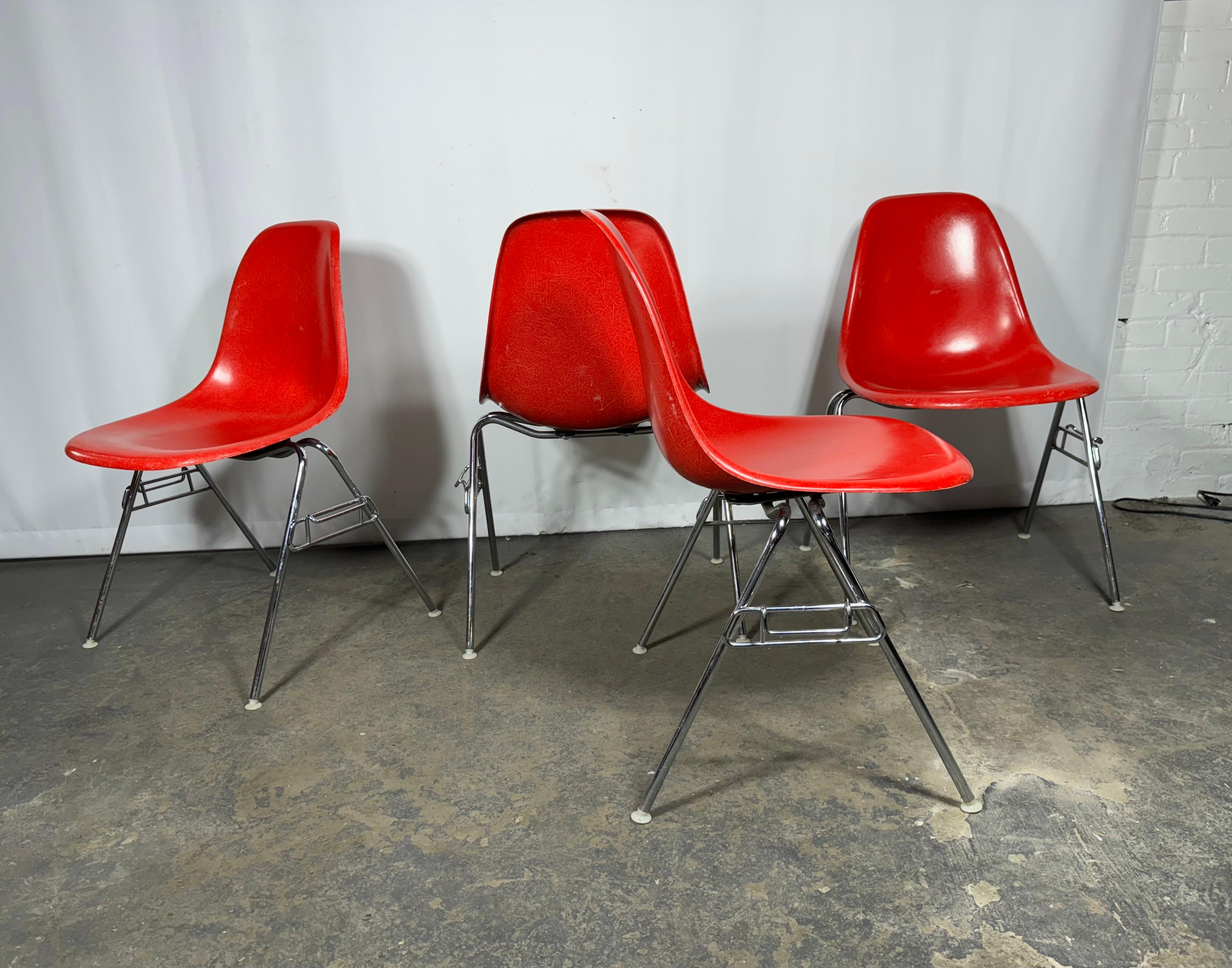 Original 1960s DSS molded fiberglass shell chairs on stacking base, designed by Charles and Ray Eames for Herman Miller. Seldom Seen Fire Engine Red shells are in original condition, each with a distinct thready exposed fibers, texture. Shown here
