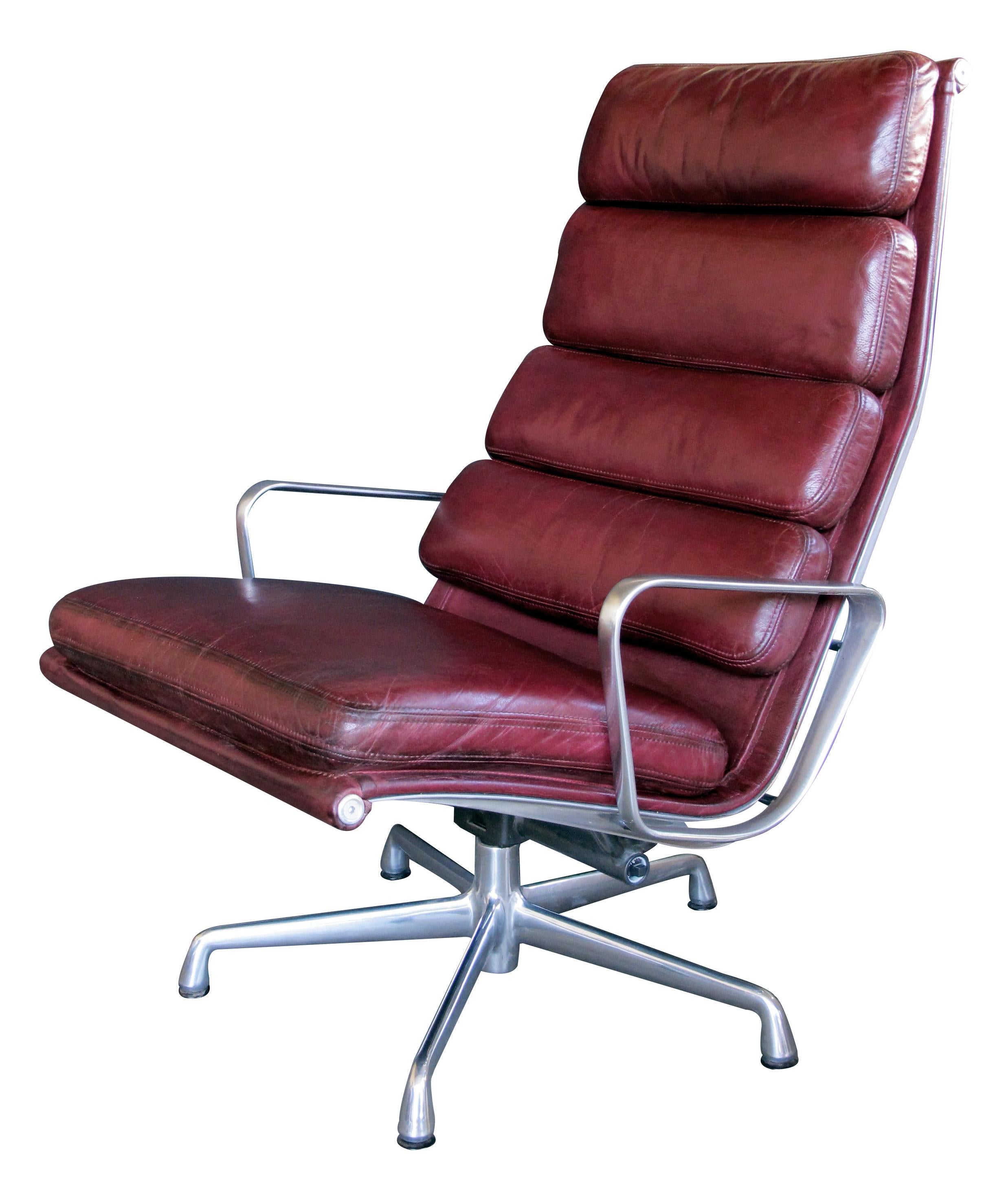 This classic design of aluminum construction with burgundy leather; original design from 1958, Eames Aluminum Group; 1980's; see '1000 chairs' by Charlotte and Peter Fiell pgs. 338-339; overall creasing and patina to leather; ottoman height 19.5