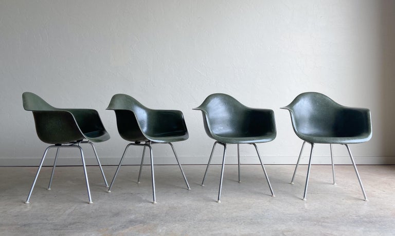 A wonderful set of four fiberglass armchairs designed by Charles and Ray Eames for Herman Miller. Offered in a rare olive green color that doesn't surface often. 

One of the most recognized designs of the early modern design movement. The Eames'