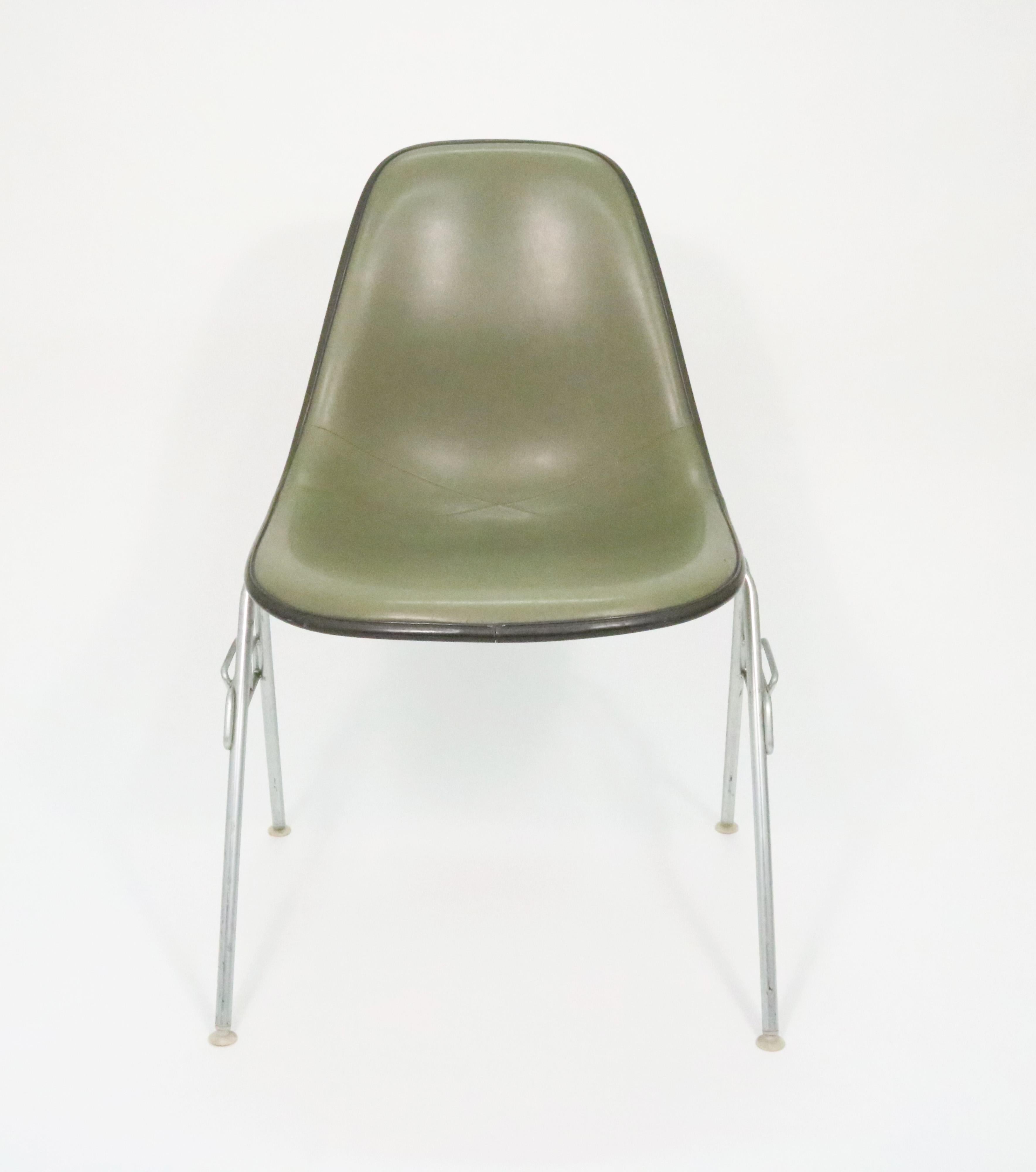 Charles and Ray Eames' molded fiberglass side chair upholstered in green vinyl with original DSS stackable cast aluminum base.

Herman Miller name and logo, as well as patents tag on the underside.