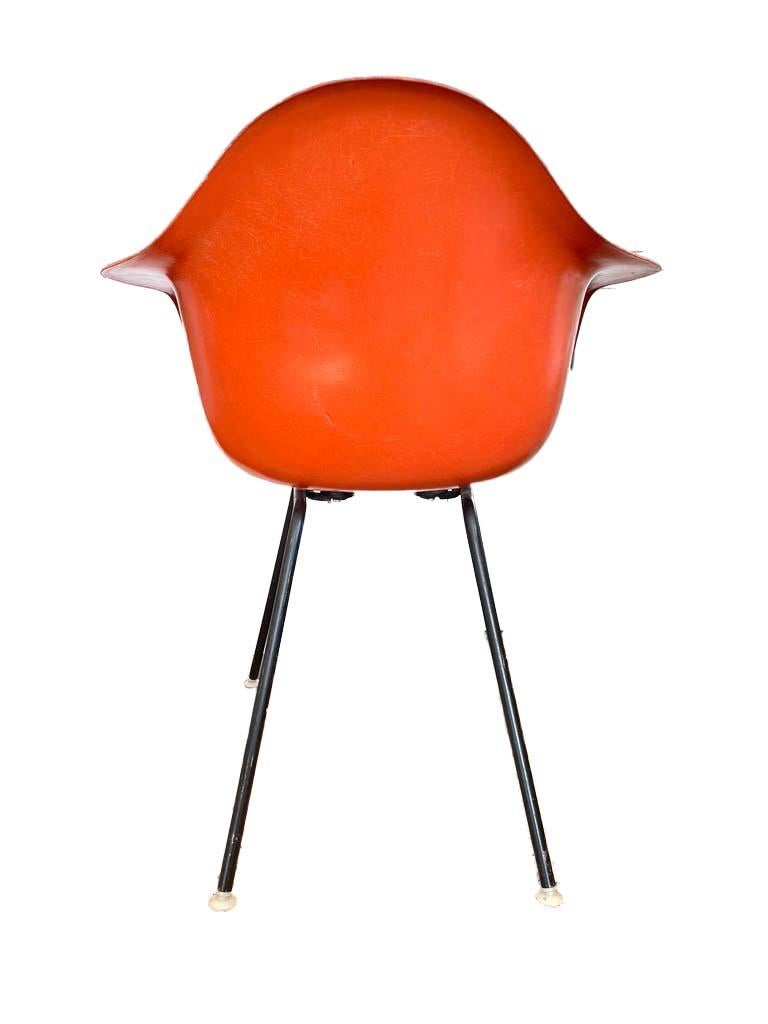 Chaise de salle à manger Eames pour Herman Miller en fibre de verre de couleur orange. Elle est estampillée Herman Miller et possède également le logo zenith Prime circle.