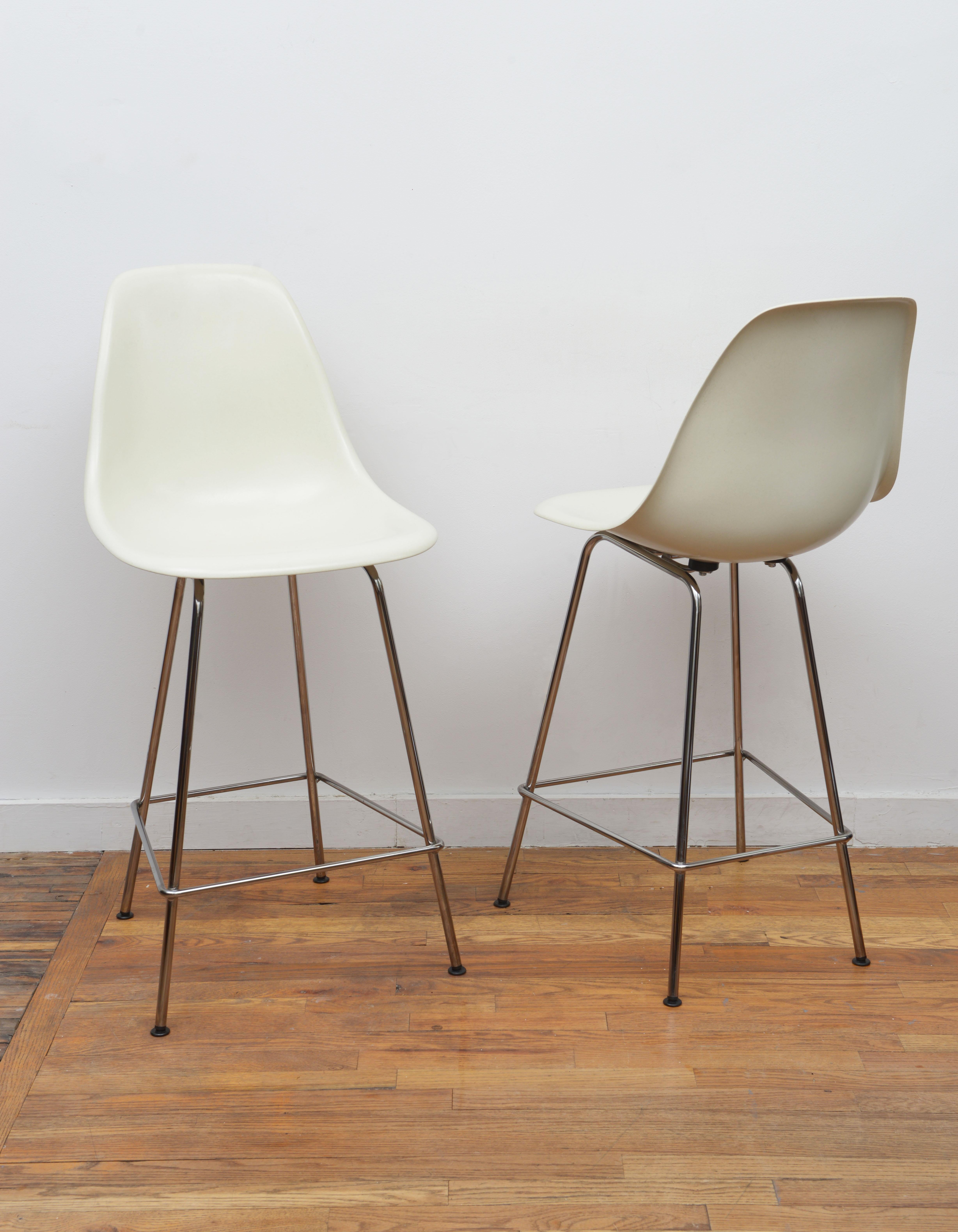 One iconic pair of white molded plastic bar stools by Charles & Ray Eames for Herman Miller, 2010. These beautiful stools were very lightly used. The perfect combination of comfort and style featuring white molded seats with chromes steel legs. Both