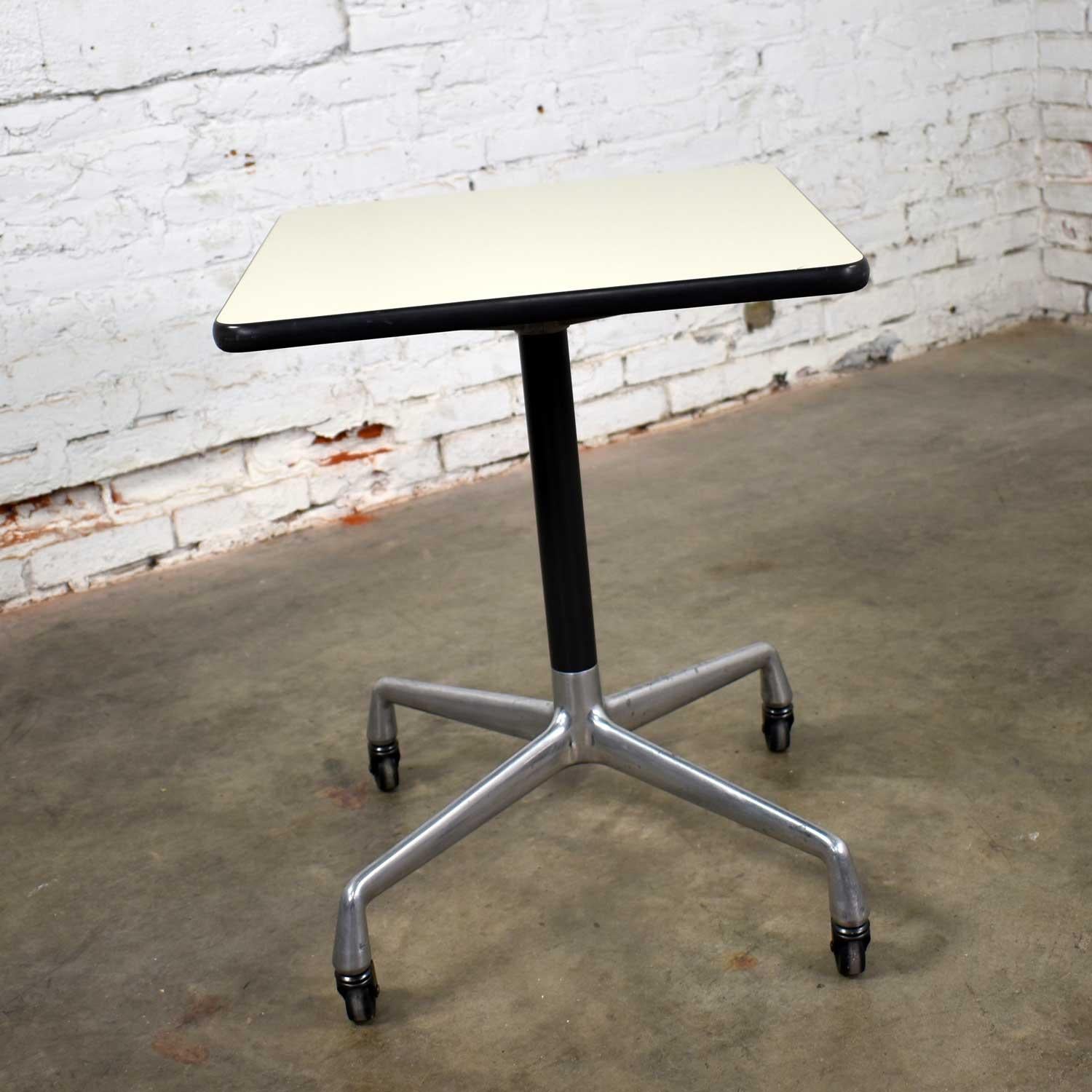 Wonderful square rolling side table designed by Charles and Ray Eames for Herman Miller. Comprised of white laminate top and universal base. In wonderful vintage condition with the normal signs of age. There is some darkening to the aluminum legs