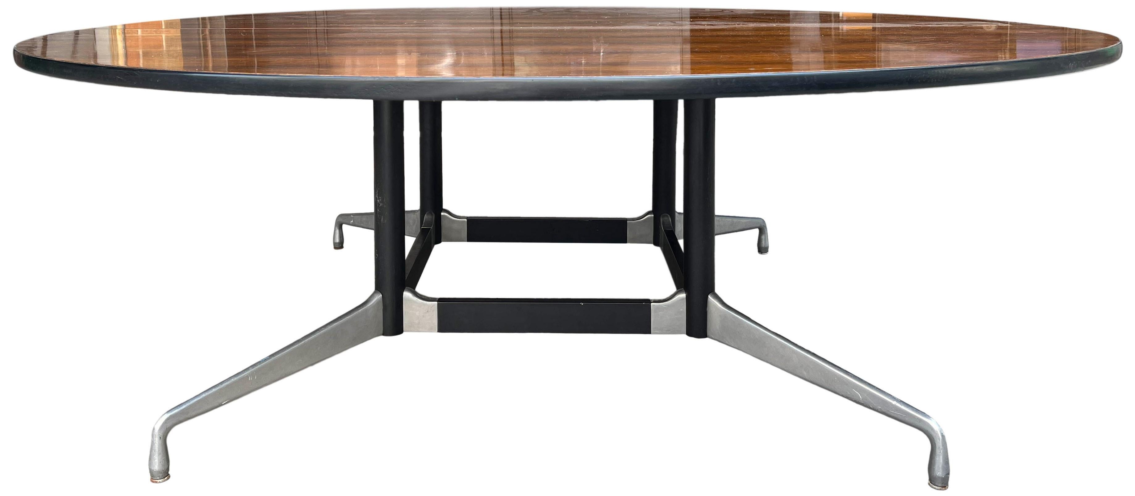 A glorious and monumental Mid-Century Modern conference table or dining table designed by Charles and Ray Eames for Herman Miller in rosewood. Segmented aluminium base with a 7’ round Rosewood top. Seats 10-12.
This table top easily separates in two