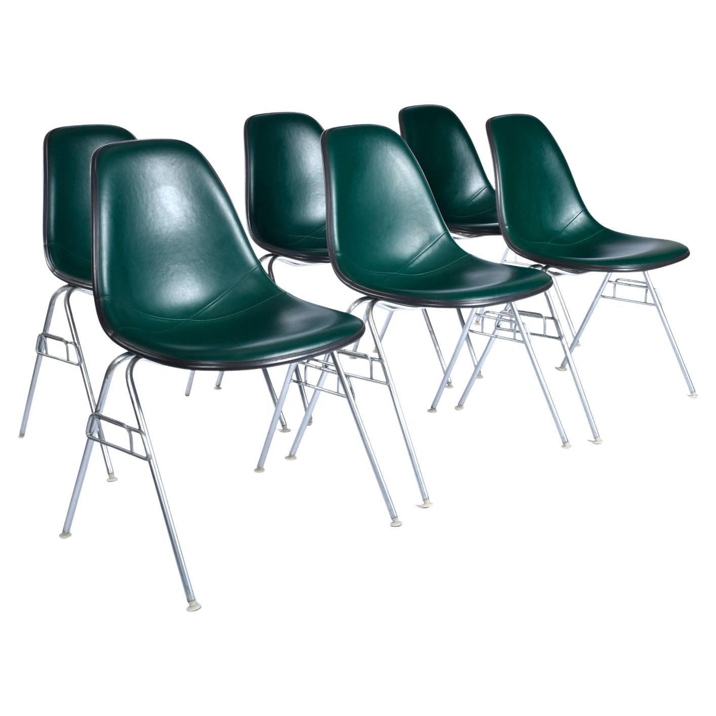 Sold as a group of six

Eames stackable fiberglass shell chairs with original green pads. The famous Charles and Ray Eames fiberglass shell chairs are outfitted with their original hunter green seat pads (cushions). Each chair bears the Herman
