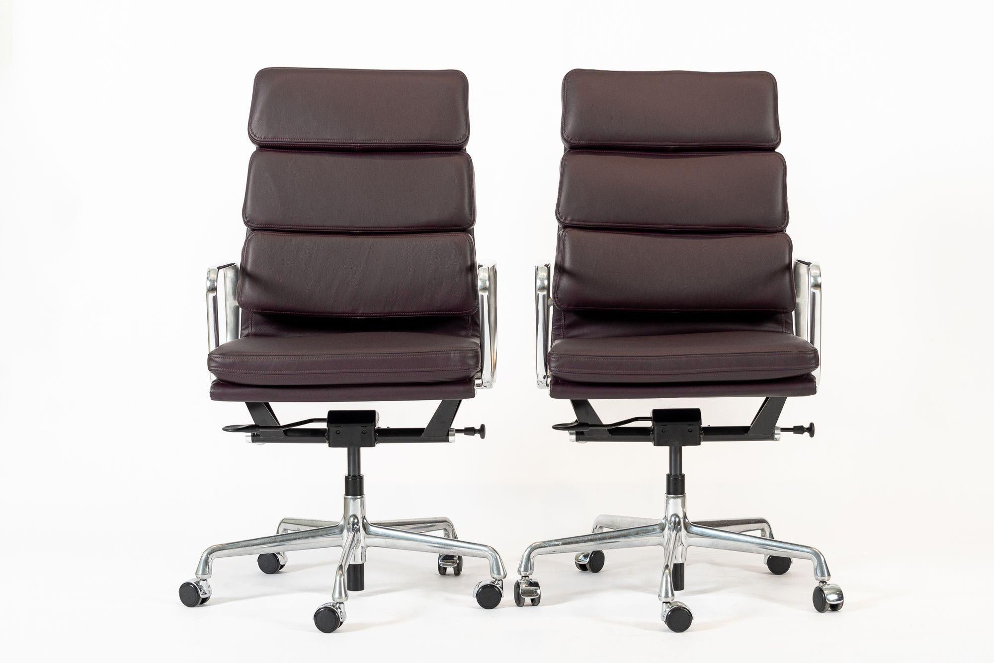 These authentic Eames for Herman Miller Soft Pad Executive Height dark purple leather office chairs from the Aluminum Group Collection were manufactured in the 2000s. This classic mid century modern office chair was first introduced in 1969 by