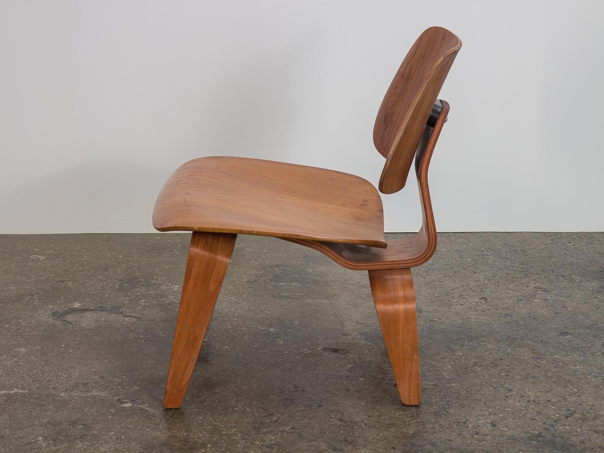 Original walnut LCW chair, designed by Charles and Ray Eames for Herman Miller. Molded plywood with a low-slung profile. Legs and seat edges are very clean with no major chips. Structurally sound--shock mounts are stable and secure. Nice original