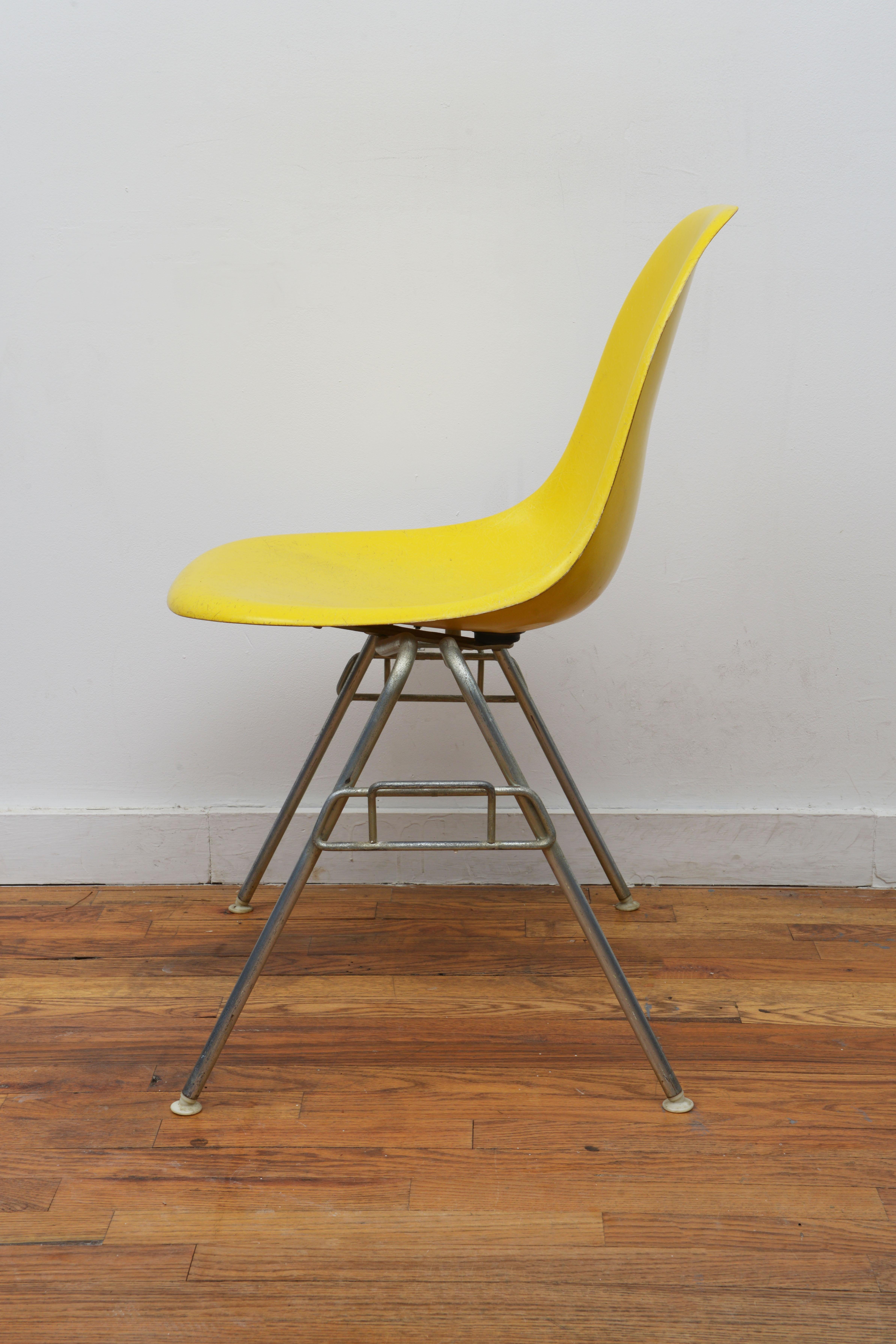 Eames for Herman Miller Yellow DSS fiberglass chair 1950s (Signed with Herman Miller logo on bottom). The chair shows traces of use like some scratches on the shells and tiny damages. This chair is very sturdy and the color is incredible. Most