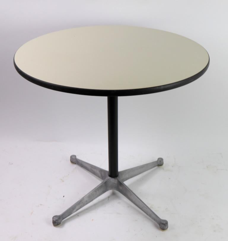 Classic architectural pedestal dining table designed by Charles and Ray Eames for Herman Miller, circa 1973. This example is in very good, vintage condition, it shows two very minor pock marks to the white laminate surface, pictured with a dime to