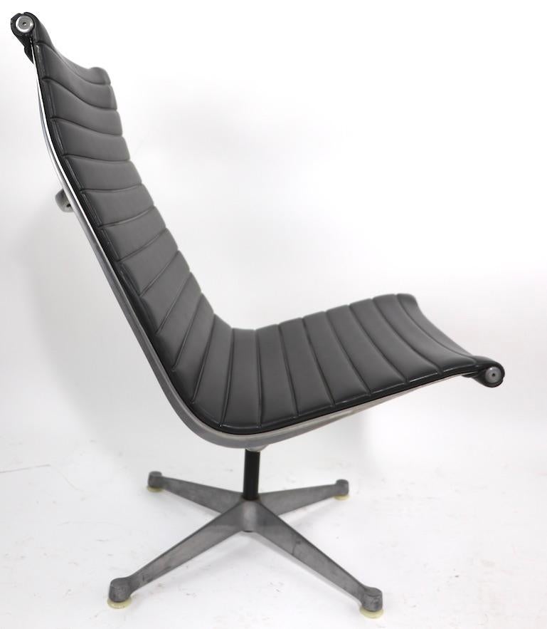 Nice early example of iconic Eames design Aluminum Group lounge chair in dark gray vinyl, circa 1950-1970. This example features the earlier version of the bases, please see images. Very good, original condition, fully and correctly marked, clean