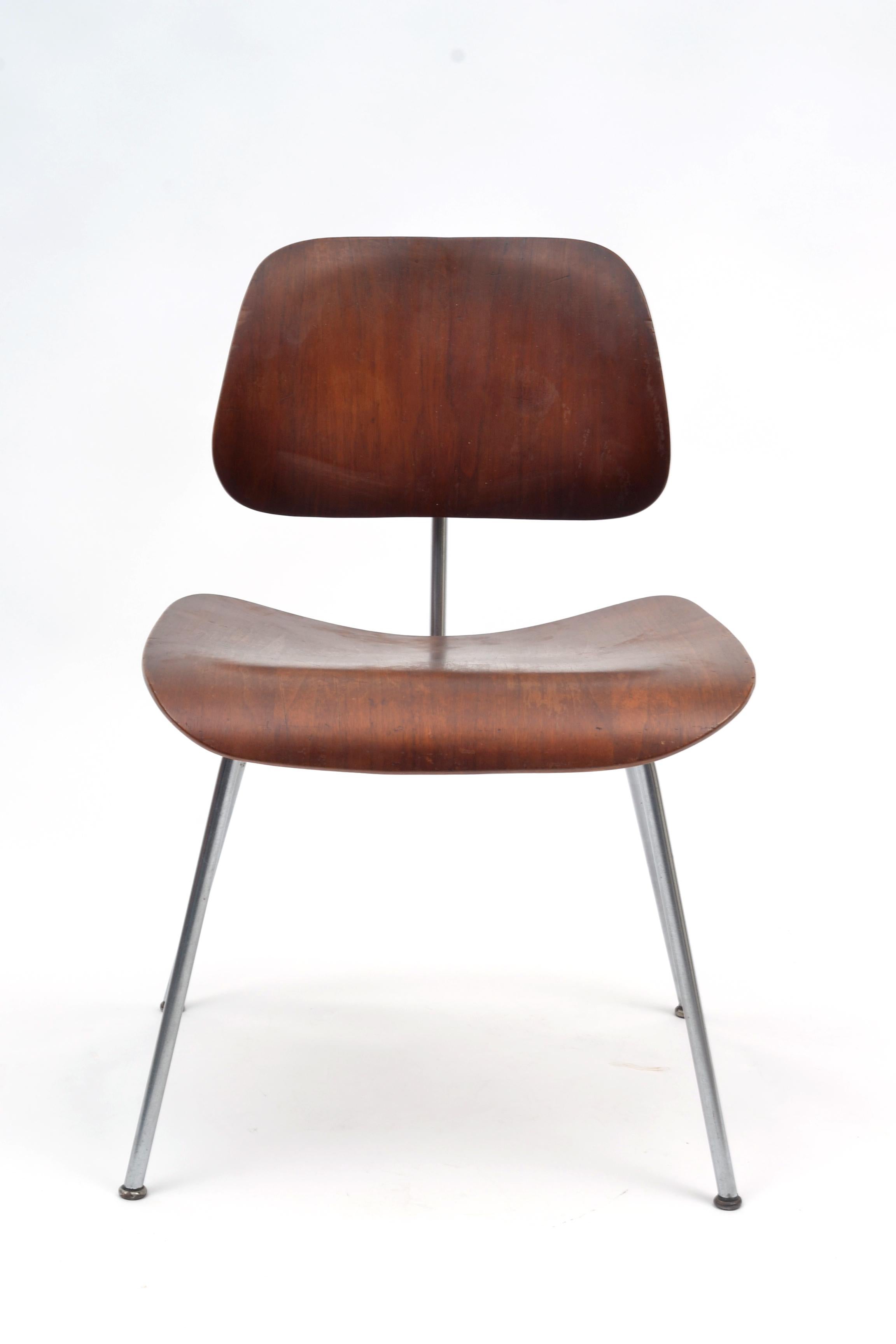 Vintage Herman Miller Eames DCM. The finish appears to be an aniline red and the backrest shockmounts have been replaced. Retains the Herman Miller foil label as pictured. The DCM is a great example of Classic Eames Office design.