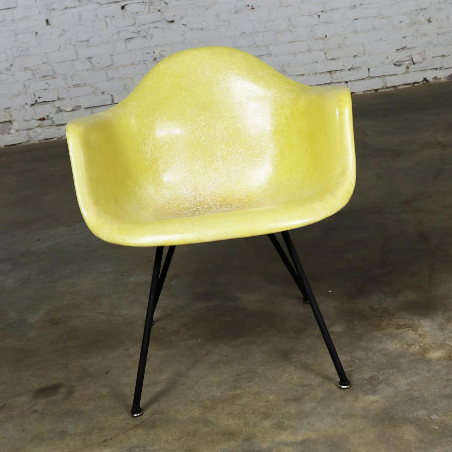 Awesome example of the Charles and Ray Eames LAX molded fiberglass arm shell chair for Herman Miller in one of the original colors, lemon yellow. This is an early chair made by Zenith with the rope edge, X-base, and checkerboard Zenith paper label.