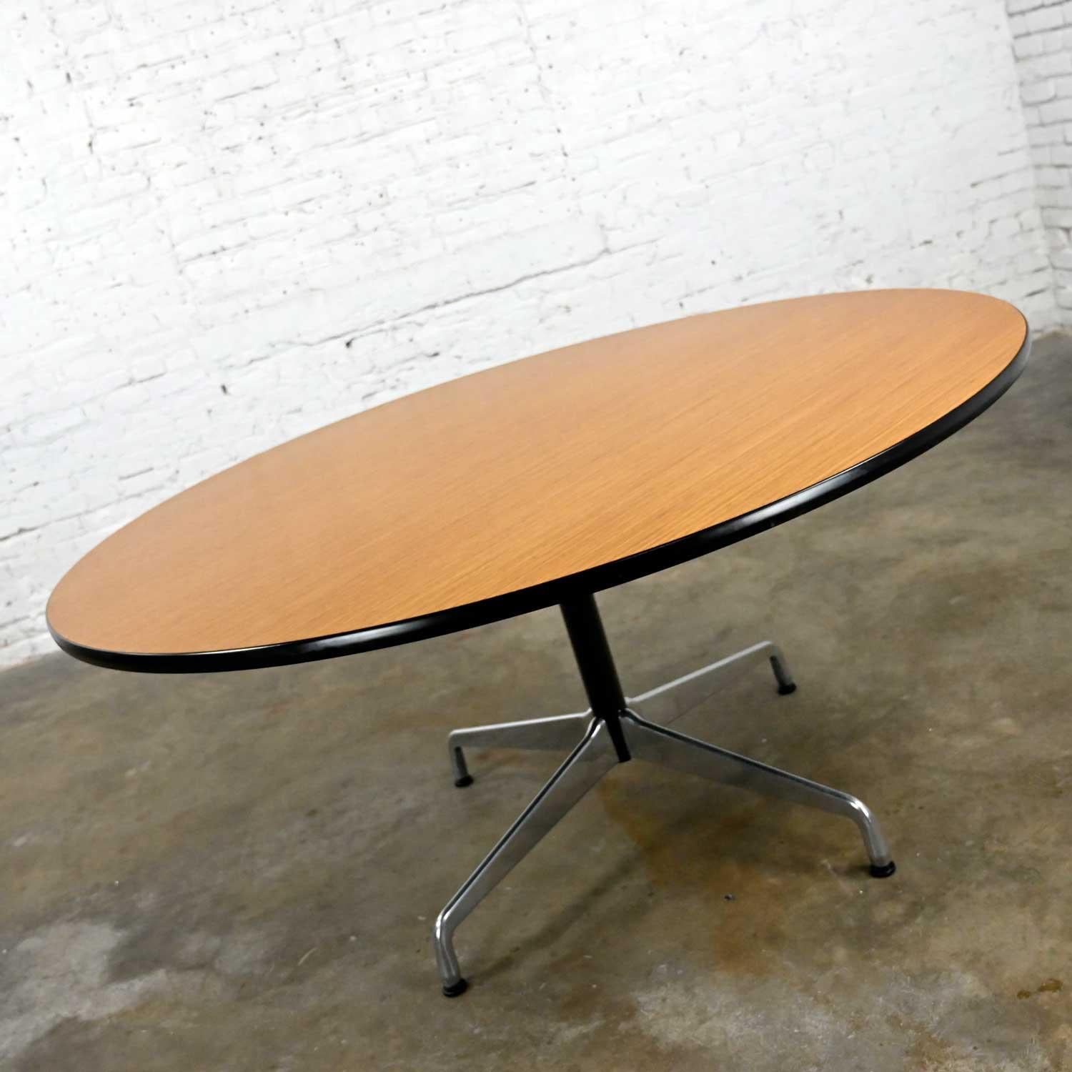 Wonderful vintage Mid-Century Modern Eames for Herman Miller table comprised of light natural oak wood veneer round tops, black shaft, aluminum universal base, and aluminum spider attachment. Beautiful condition, keeping in mind that these are