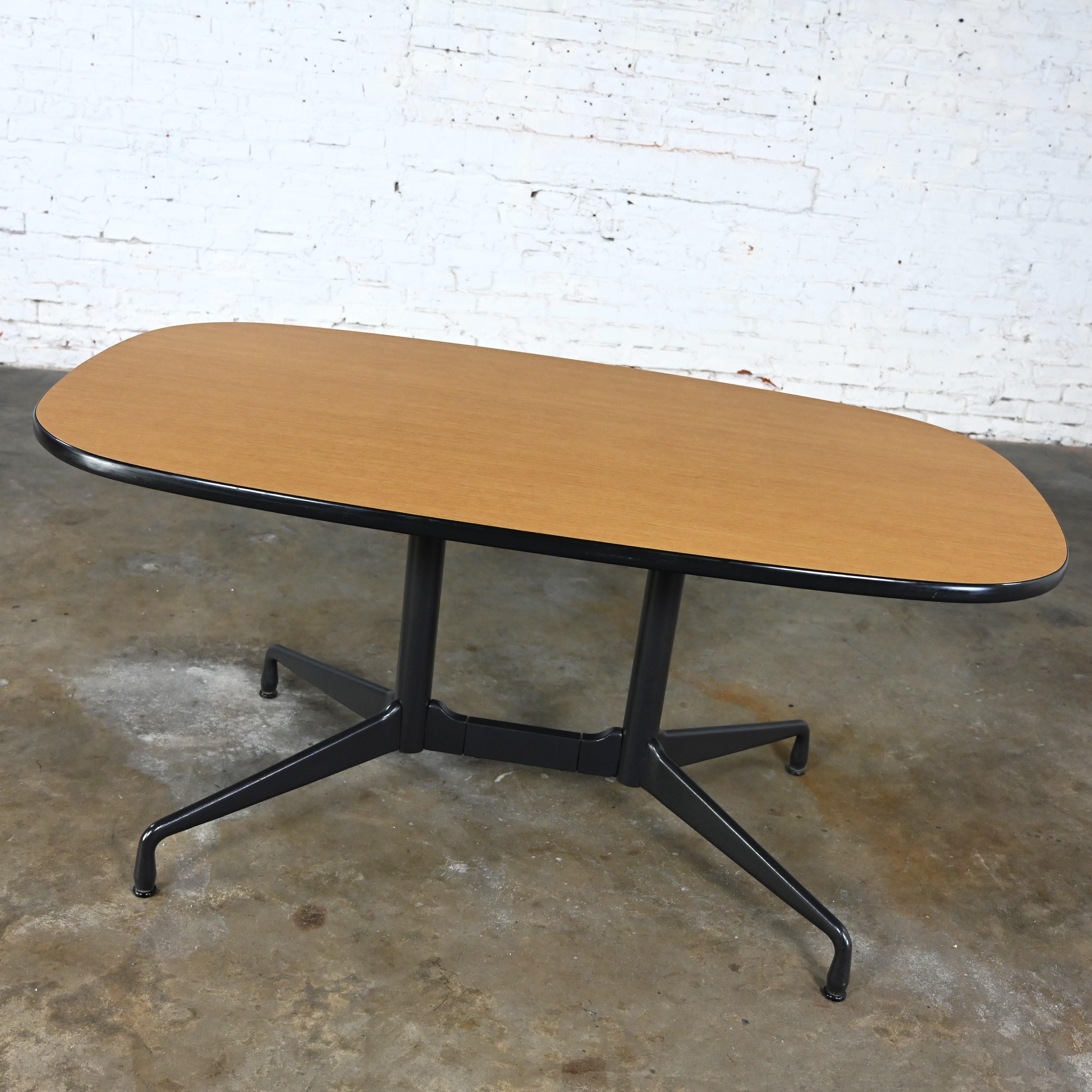 Incroyable table de conférence ou de salle à manger vintage MCM (Mid-Century Modern) Eames pour Herman Miller racetrack ovale avec une base universelle segmentée noire et un plateau en stratifié blond clair avec bordures en vinyle noir. Byit, en