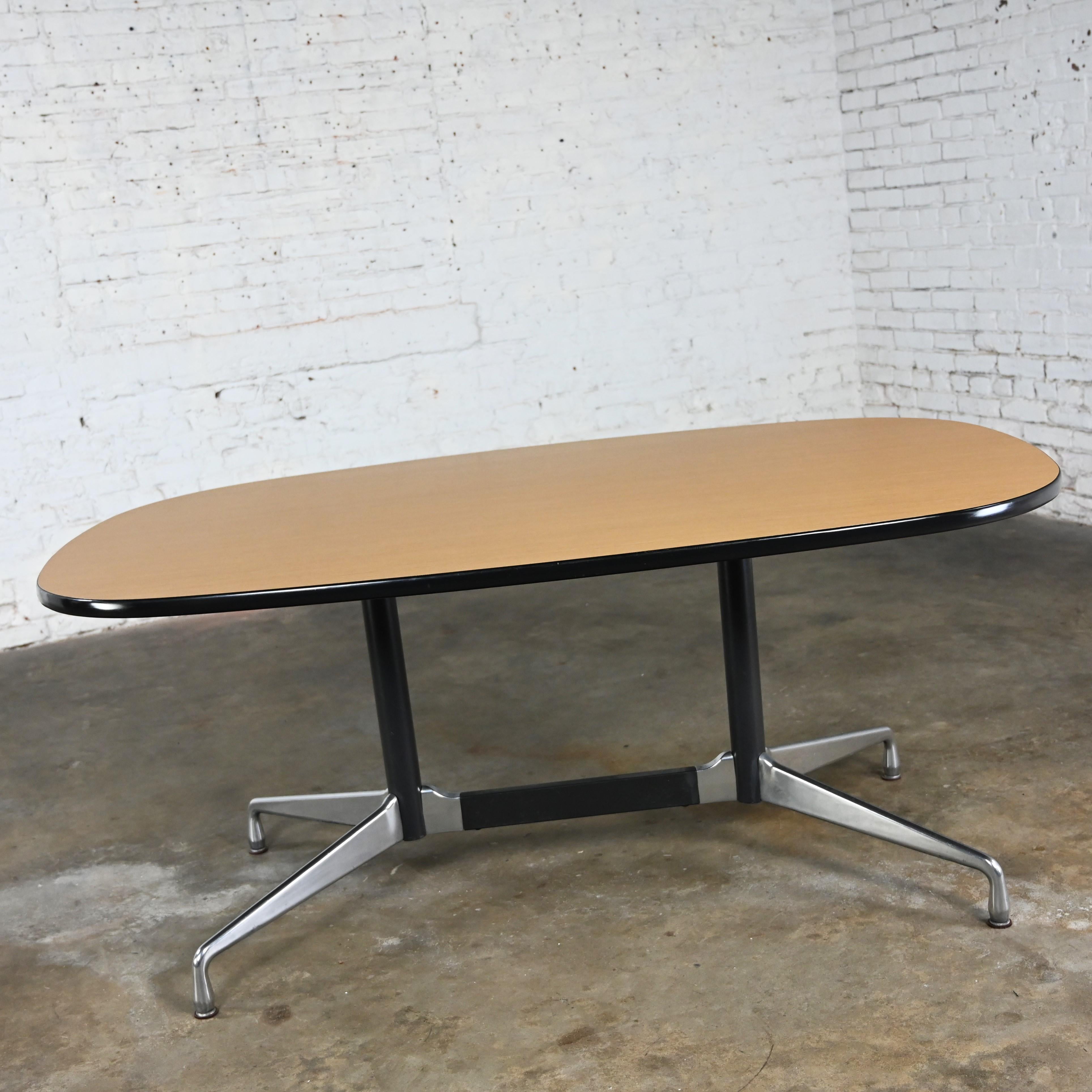 Fabulous vintage MCM (Mid-Century Modern) Eames for Herman Miller racetrack oval conference or dining table with a black & aluminum universal segmented base and blonde laminate top with black vinyl edge banding. Beautiful condition, keeping in mind