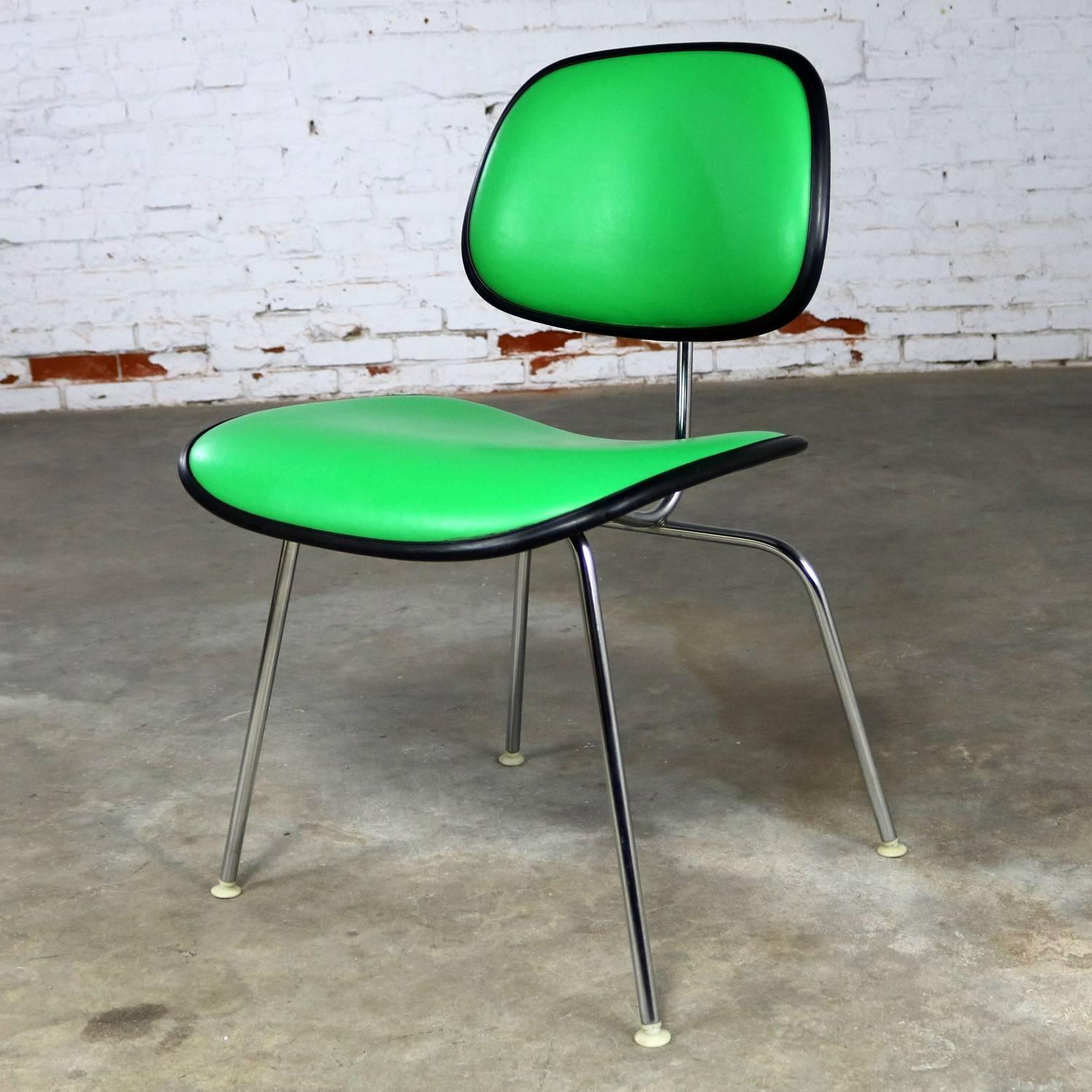 Handsome and Classic EC-127 padded DCM chair, or dining chair metal, by Charles Eames for Herman Miller. This one is upholstered in Kelly green Naugahyde, black trim and black seat and back, with chrome legs. It is in exceptionally good vintage