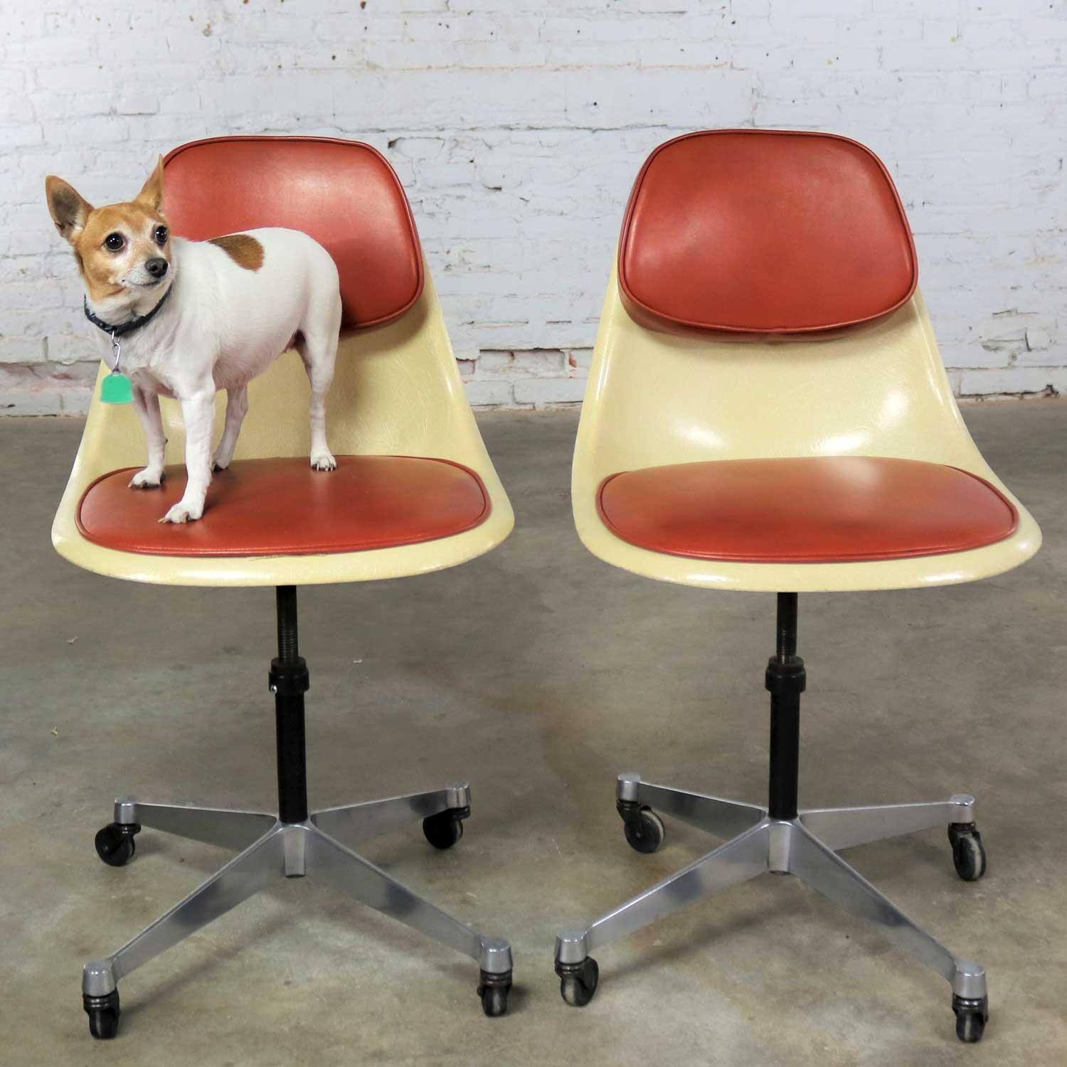 Handsome and interesting pair of Herman Miller pivoting and adjustable task shell chairs on contract bases with casters. These chairs were designed by Charles and Ray Eames and are part of the Fiberglass Series. They are in fabulous vintage