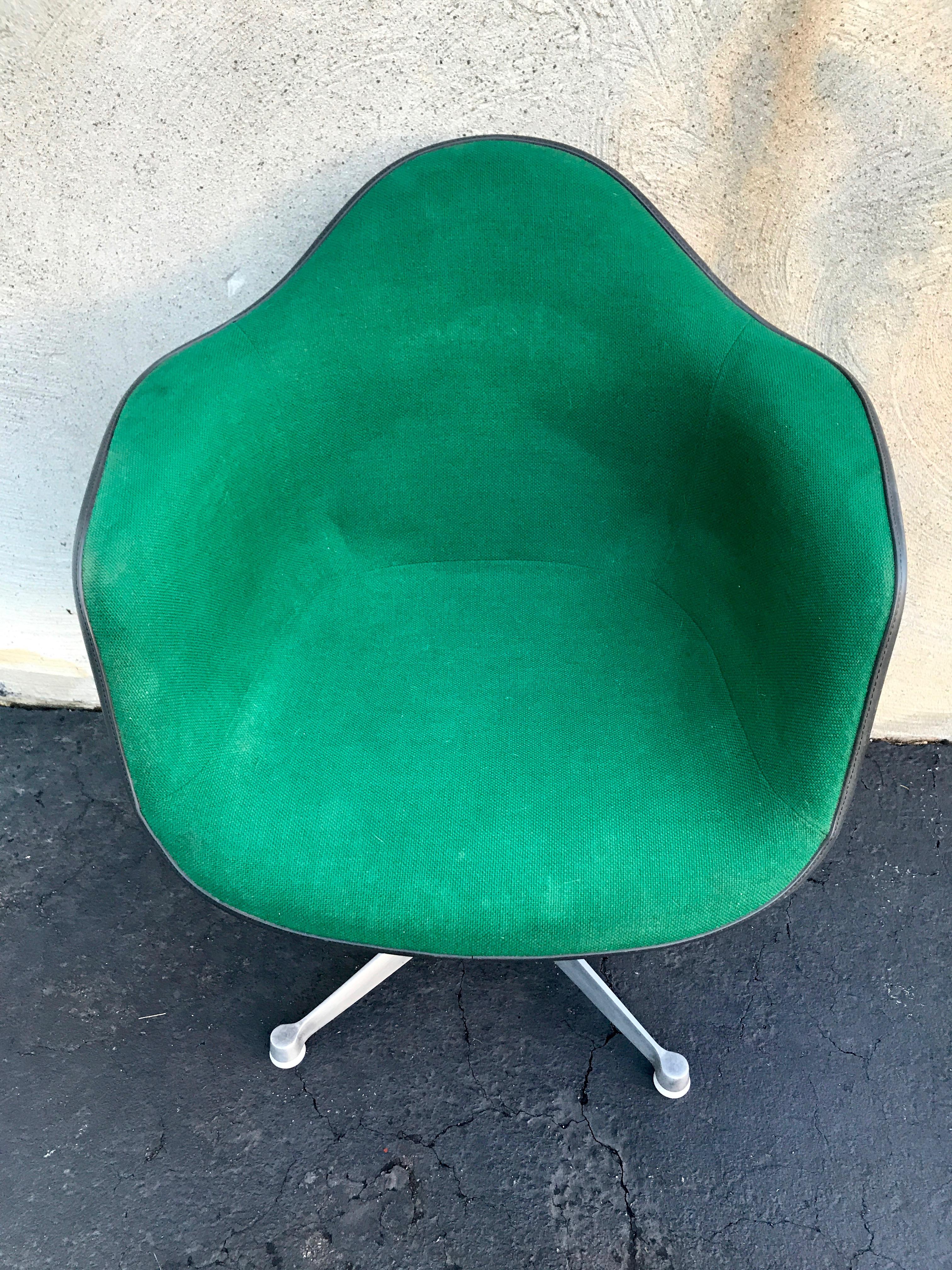 Eames Herman Miller shell chair with rare green fabric and swivel base. Has a few scratches on the back from someone swiveling it into the wall, but overall good condition. Has original stickers still on the bottom. 31