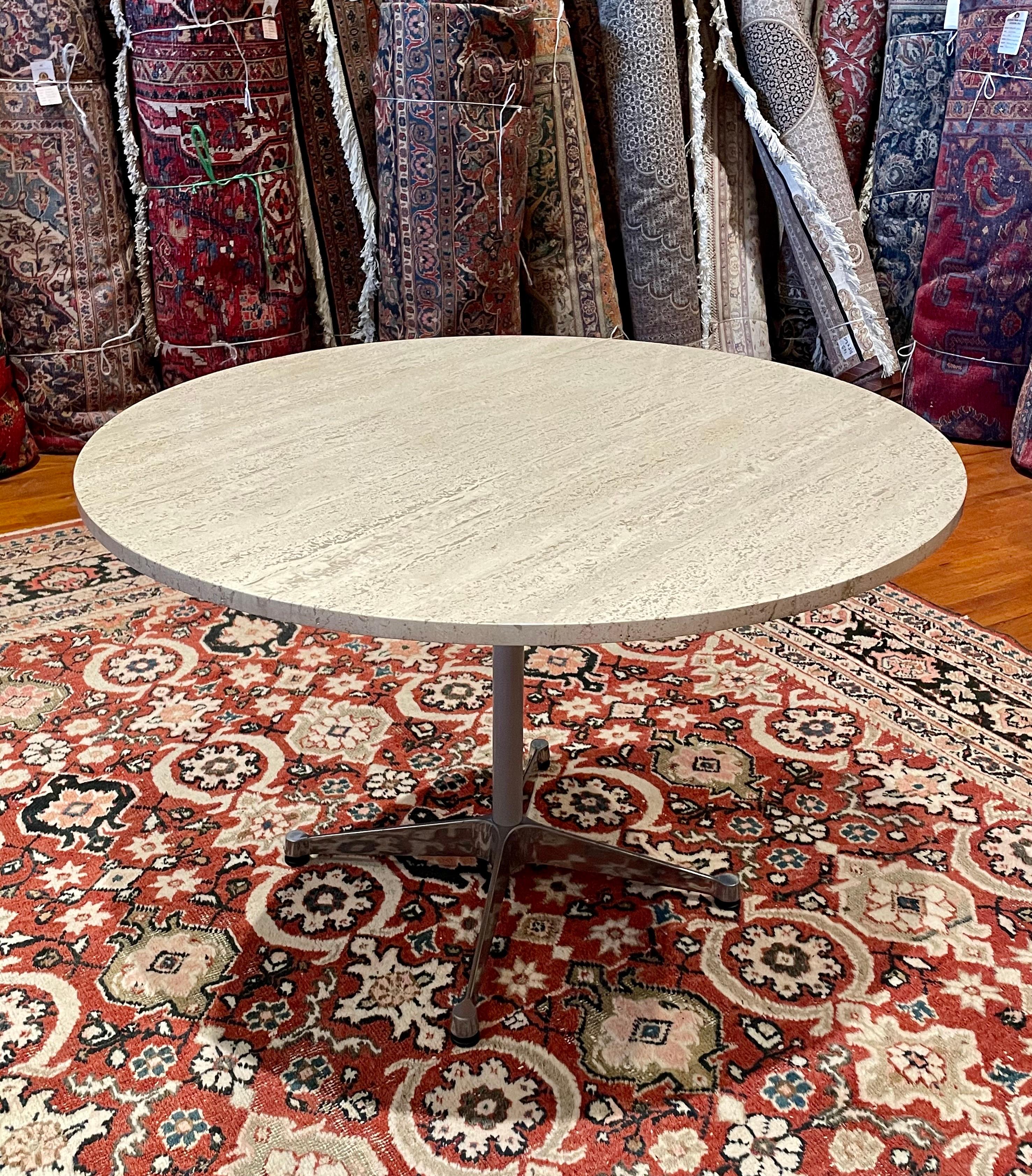 A beautiful custom-made dining table in Travertine with an aluminum table base. designed by Eames for Herman Miller in nice clean condition. marble sits on top solid and sturdy.