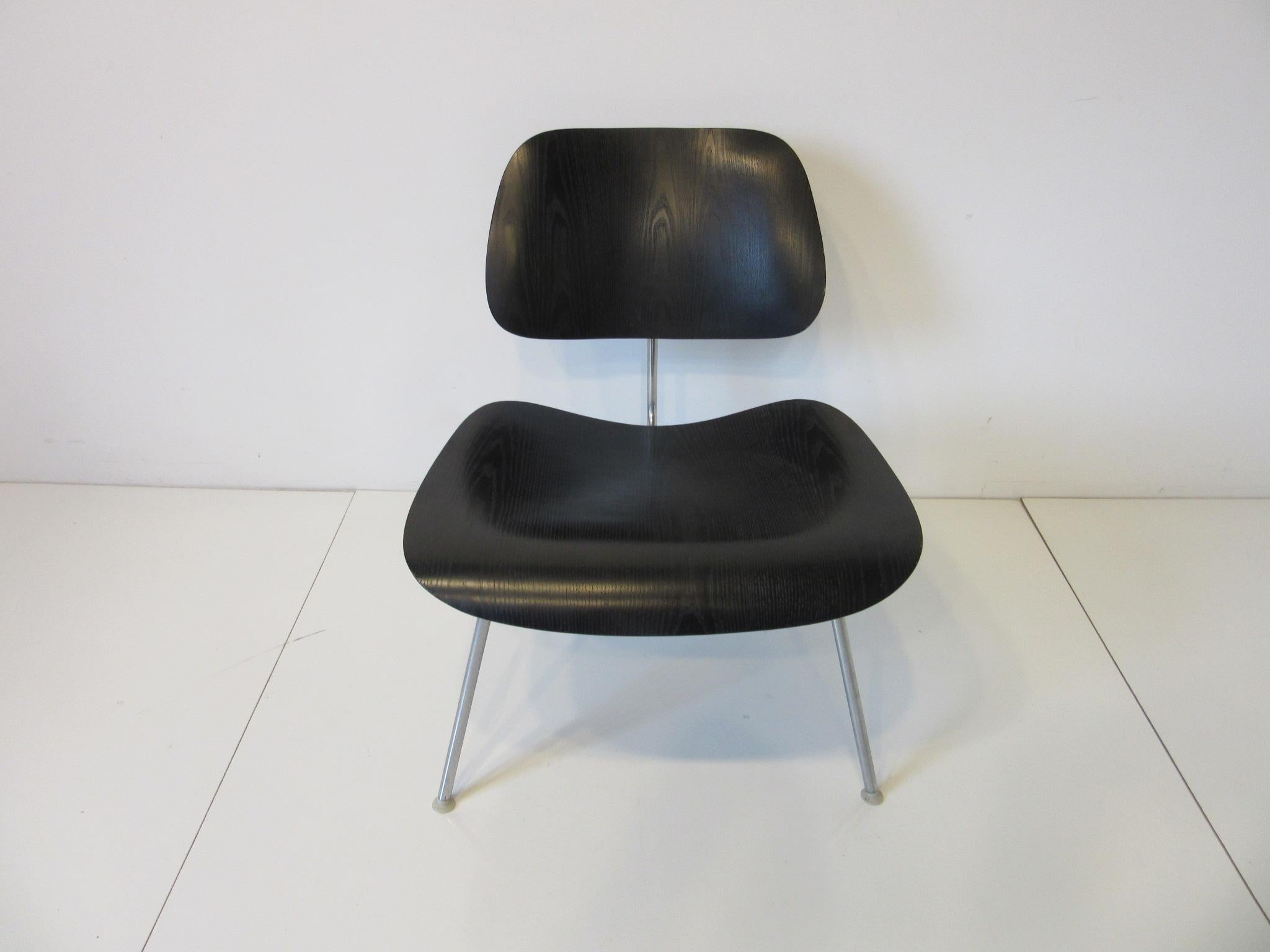 A black bent plywood LCM (lounge chair metal) chrome framed chair with nylon feet designed by Ray and Charles Eames manufactured by the Herman Miller Furniture Company.