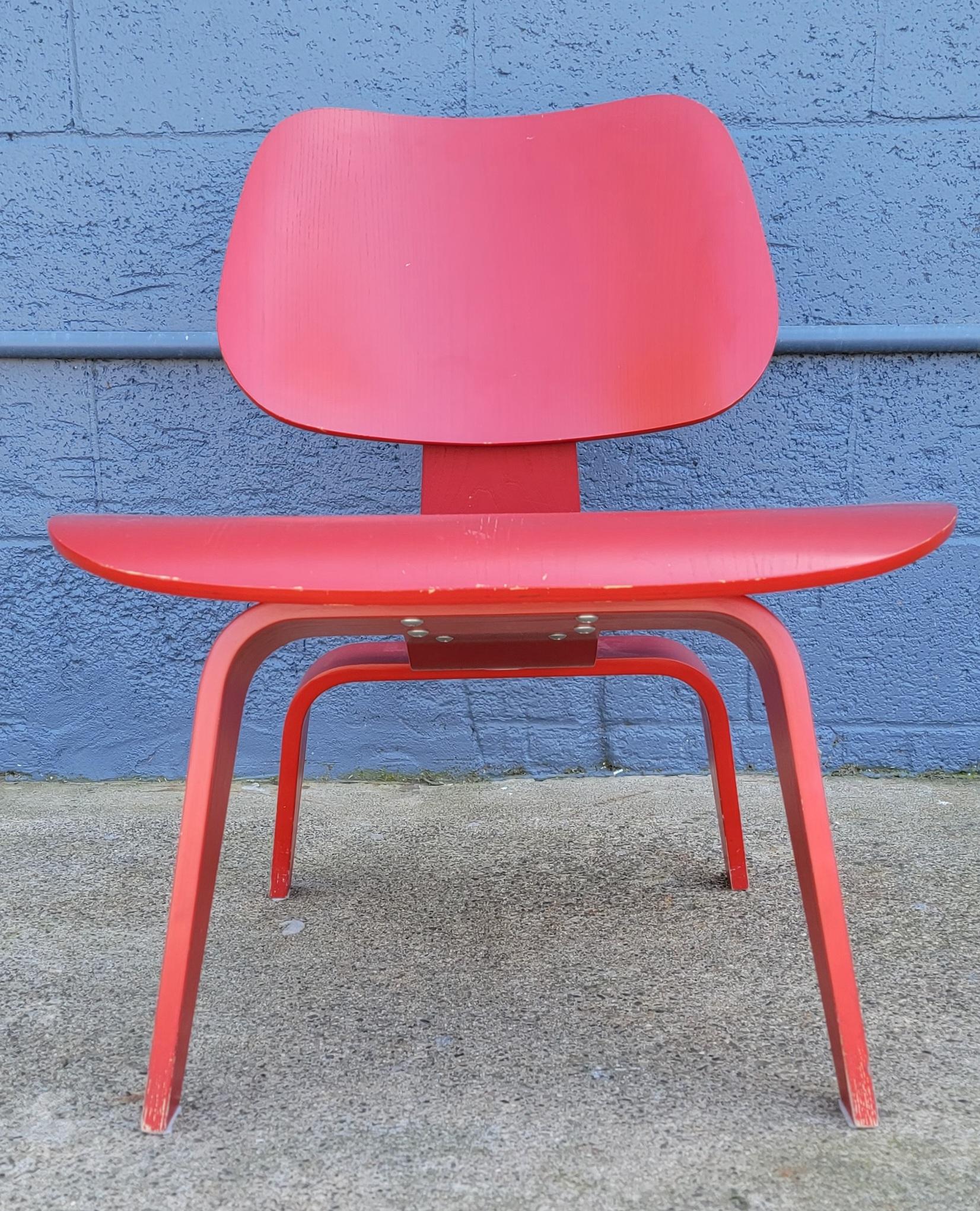 Classic Charles and Ray Eames LCW molded plywood lounge chair with original red paint. Retains Eames / Herman Miller label. Very sturdy construction.