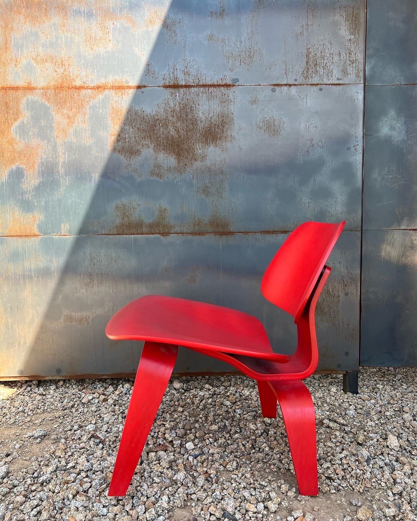 Eames molded plywood LCW (lounge chair wood) designed in 1946 by Charles and Ray Eames for Herman Miller. The red is the original finish, and it’s an official production from 2003. It is labeled underneath. The chair is in excellent condition, like