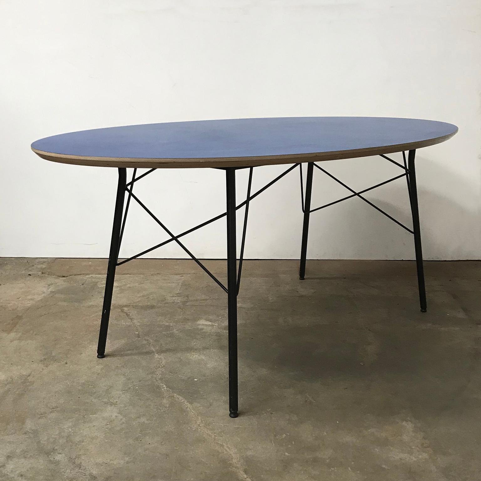 Oval table with blue top and black elegant base. The table has an elegant design with the shape of the table top and the beautiful base and legs, The table shows some traces of wear like some minor scratches (#11, #12 and #15) and one brown little