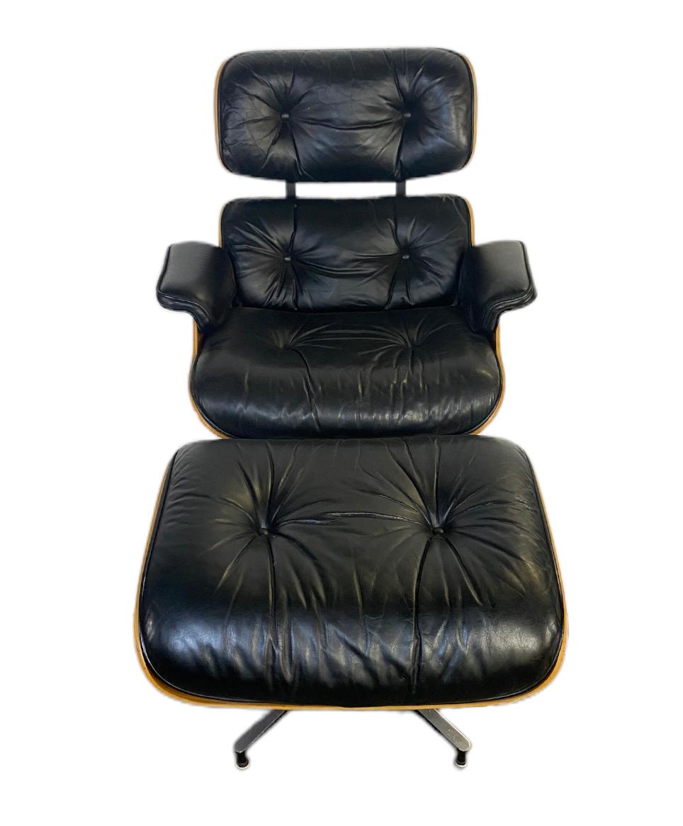 The most classic modern chair in iconic form. This vintage Eames chair and ottoman are an original pair with matching wood tones and black leather. Signed and guaranteed authentic, black leather cushions with foam filling. Extremely comfortable and