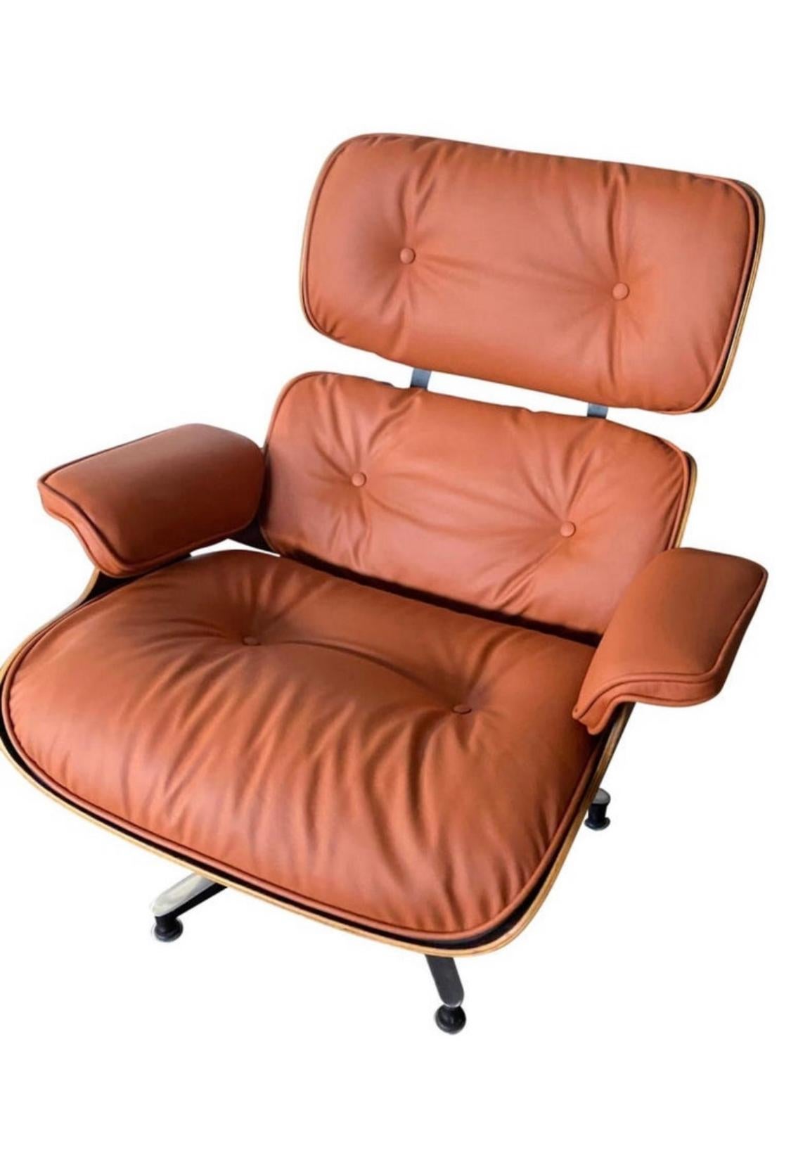 Beautiful custom edition of the iconic Eames lounge chair and ottoman. Rosewood shells have been restored and cradle the custom burnt orange leather cushions. New leather very soft and made to order (3-4 week production period). . Chair signed and