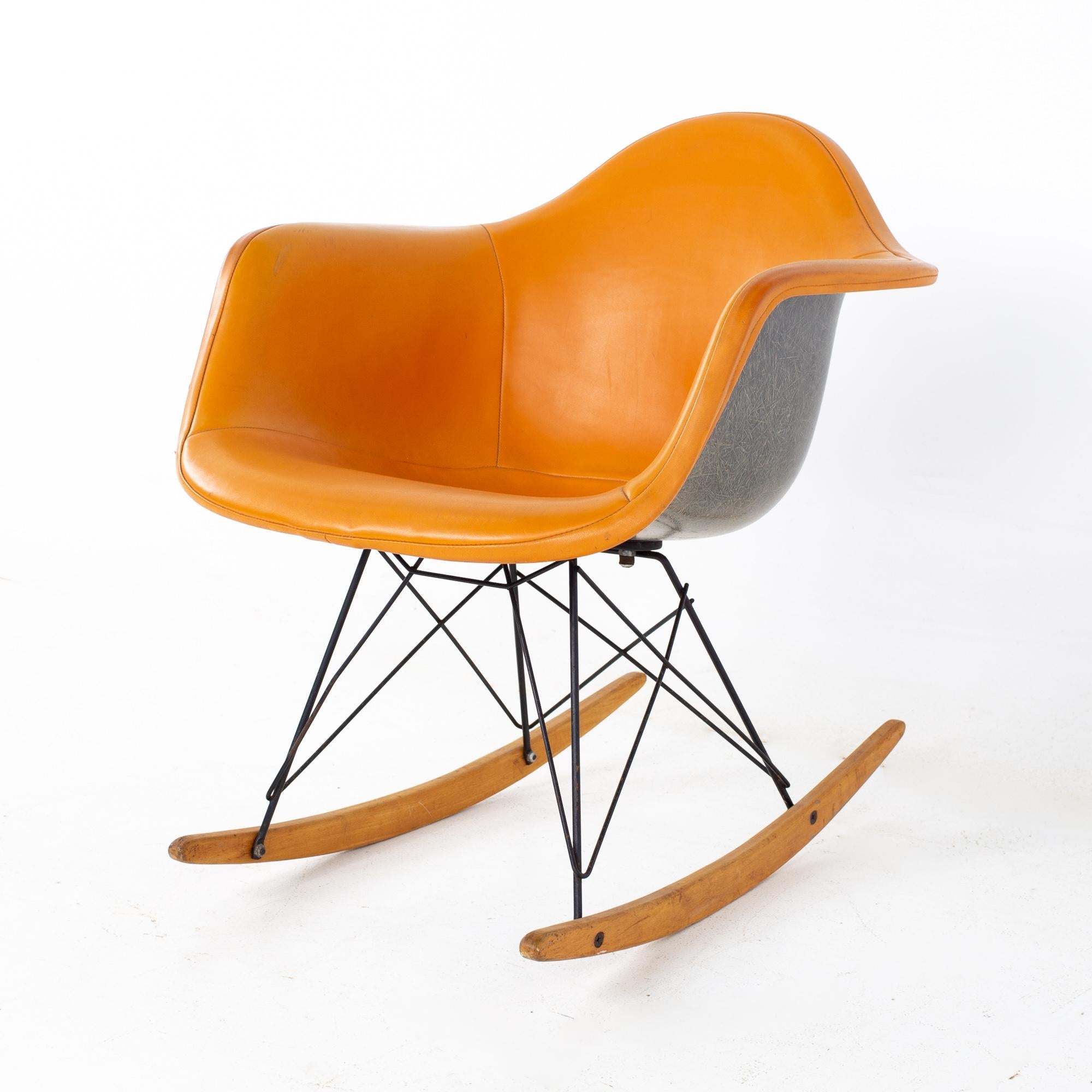 Charles Eames for Herman Miller Mid Century Orange Fiberglass Shell Rocking Chair 
Chair measures: 25 wide x 25 deep x 27.5 high, with a seat height of 16 inches and arm height of 23.5 inches

 All pieces of furniture can be had in what we call