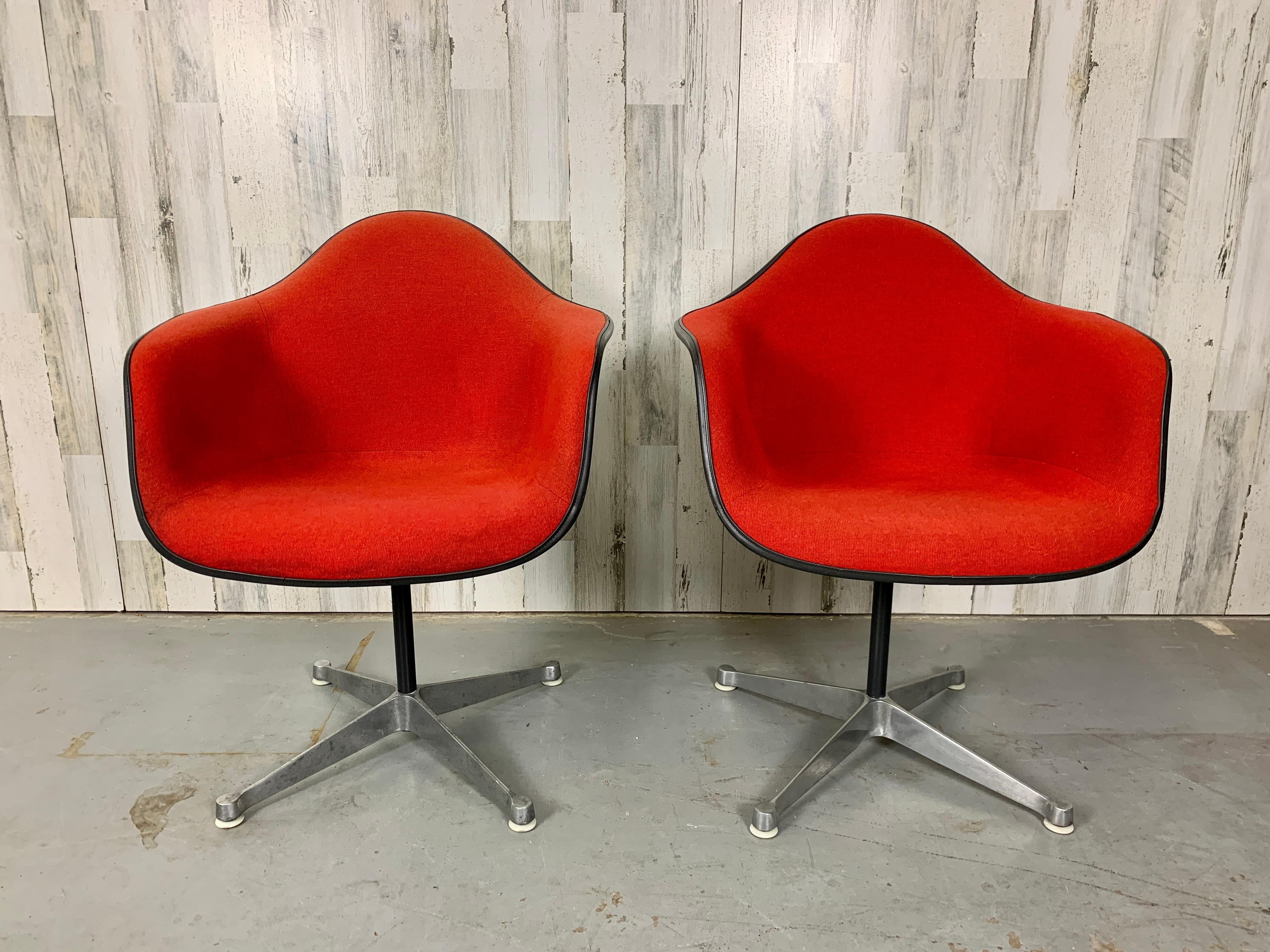 Pair of Iconic Eames for Herman Miller fiberglass shell chairs with original red wool padded upholstery.