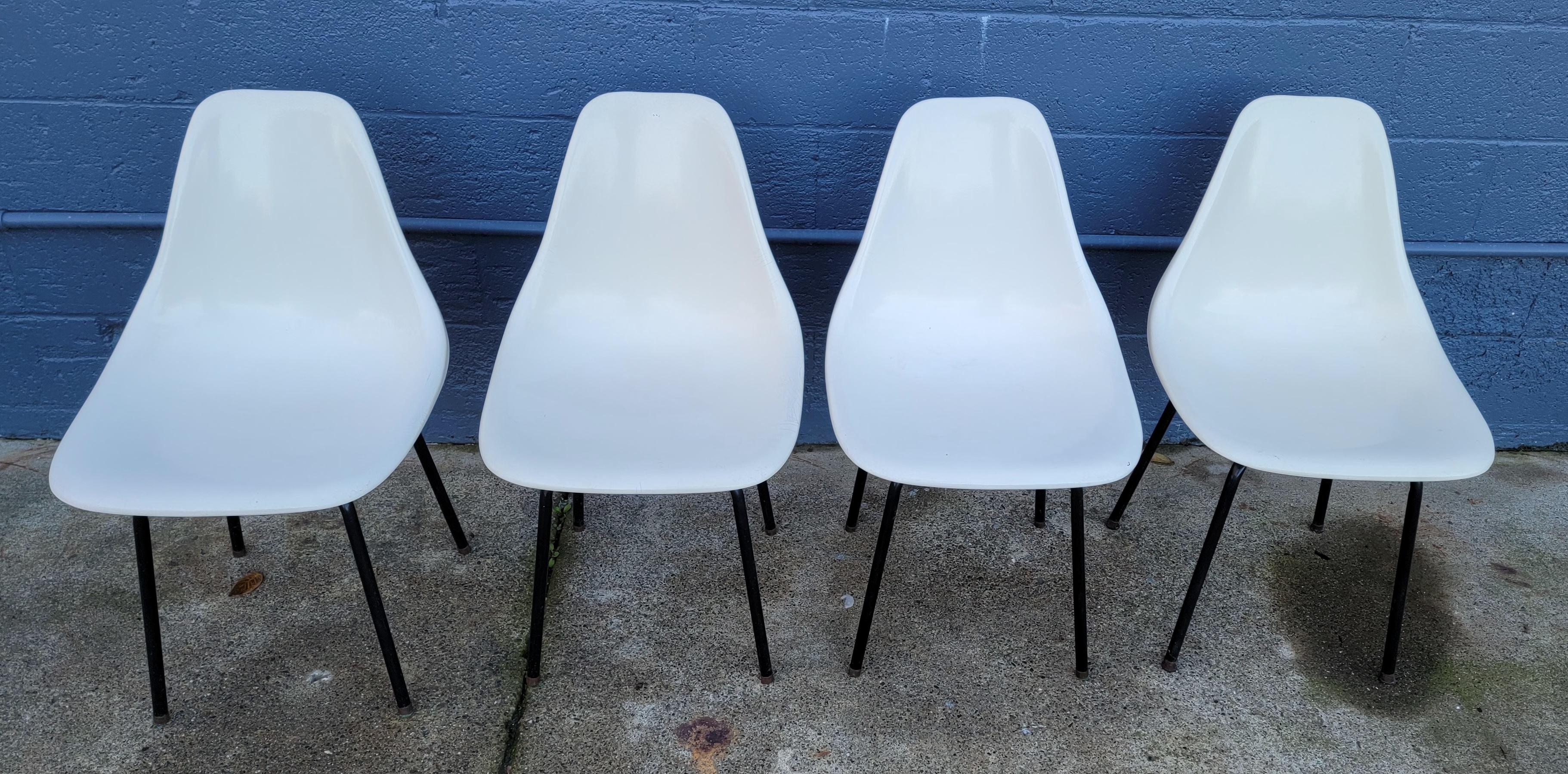 A set of 4 period Mid-Century Modern formed fiberglass dining chairs, circa. 1960's. Tubular steel legs with original black paint, white fiberglass seats. In very good original condition with age appropriate wear. Sturdy. Price friendly as an