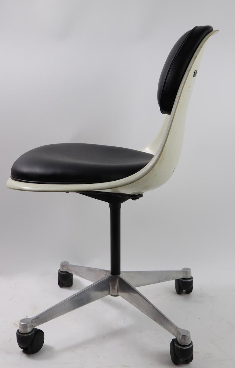 Hard to find form, fiberglass shell with attached pad seat upholstery, designed by Eames for Herman Miller. Swivel seat mounted on four star cast aluminum base. Clean and ready to use, seat pads newly reupholstered in black vinyl.
  