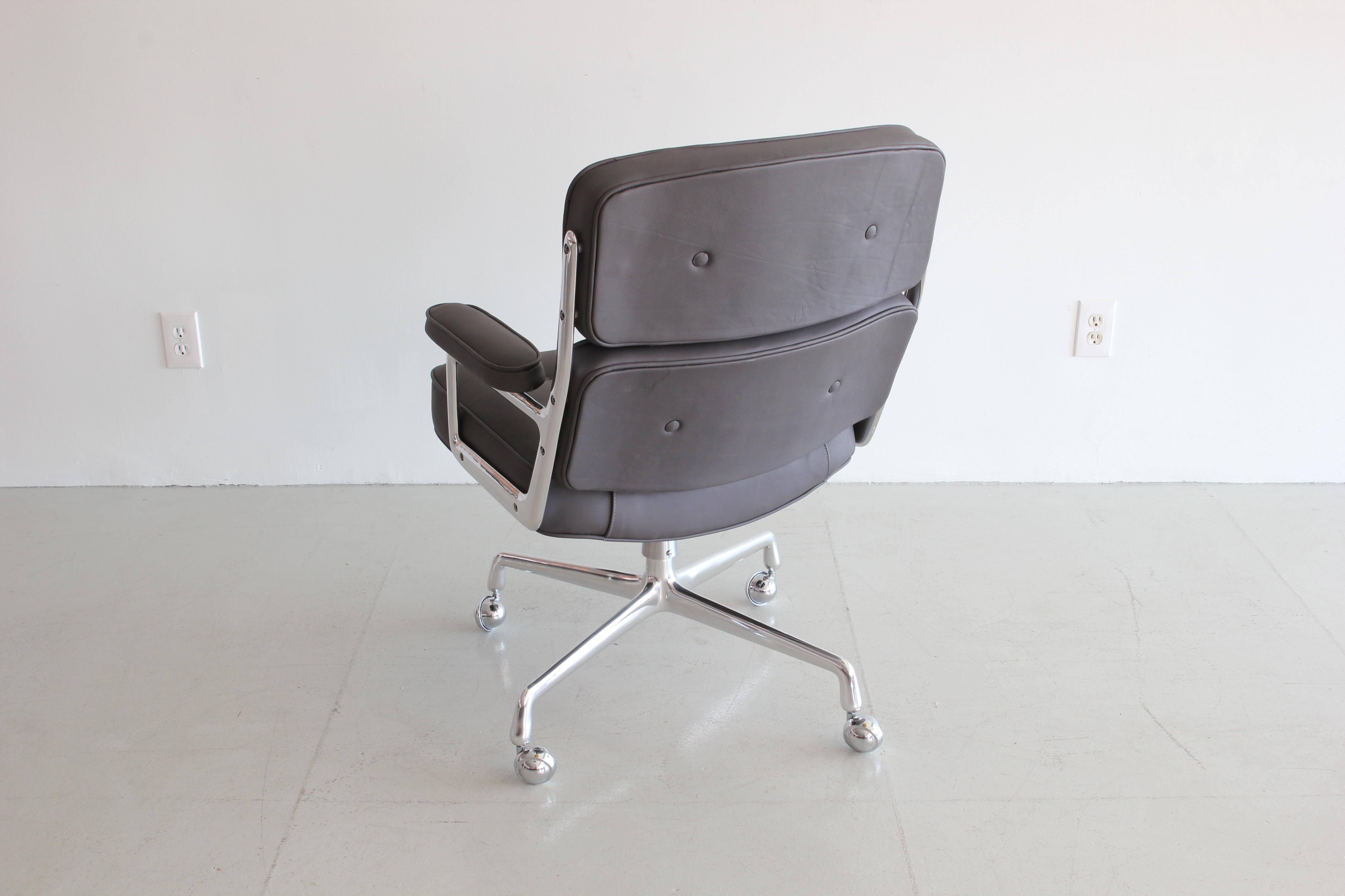 Classic office chair from the Time Life building in New York. Designed by Eames featuring newly upholstered in grey leather, new casters and a newly polished aluminum base and frame. Chair is height adjustable with tilt and swivel.