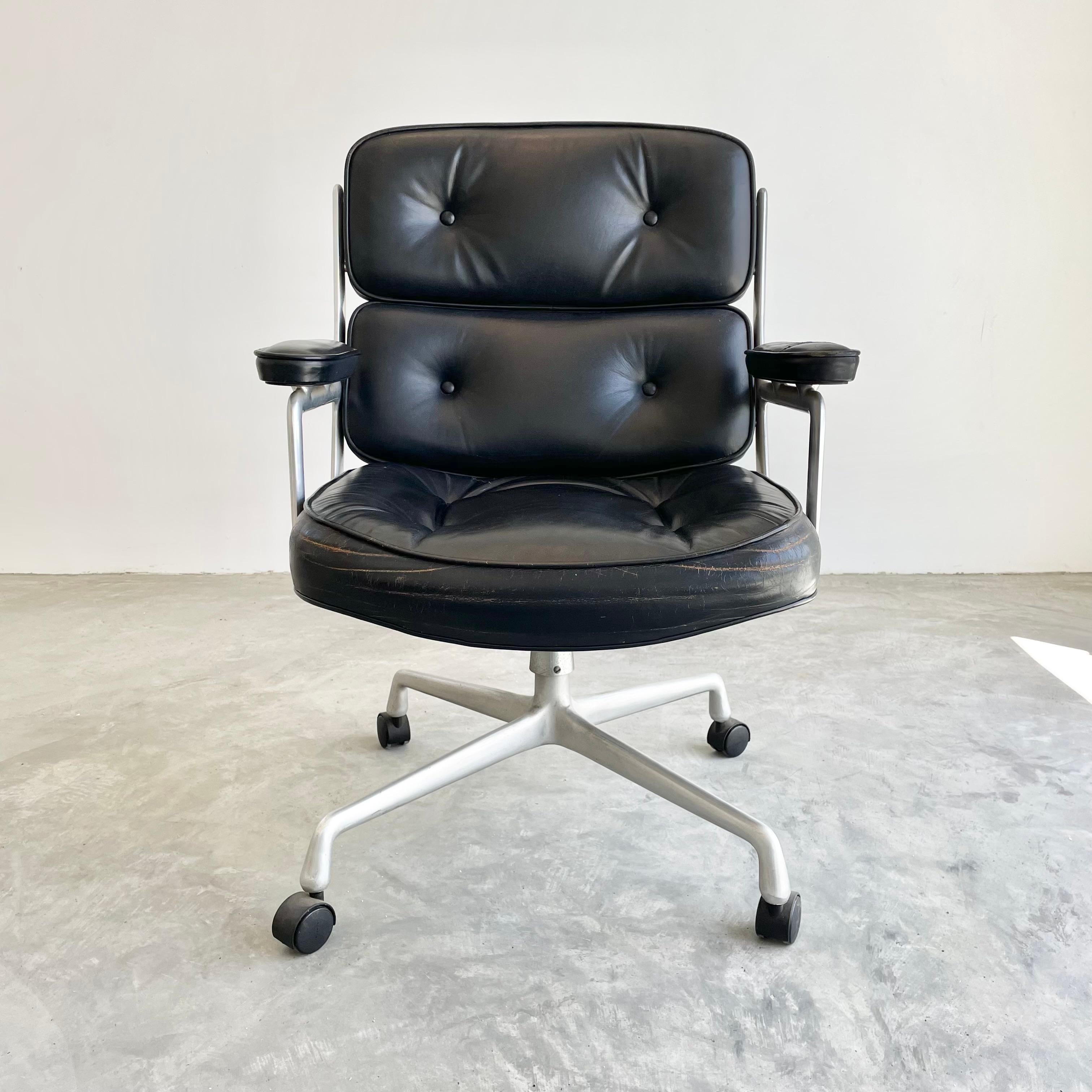 Classic Eames Time Life swivel chair in black leather for Herman Miller. Great color and patina to aluminum frame. Original black leather with some wear as shown. Extremely comfortable and worn in. Chair swivels. Chair reclines. Height is