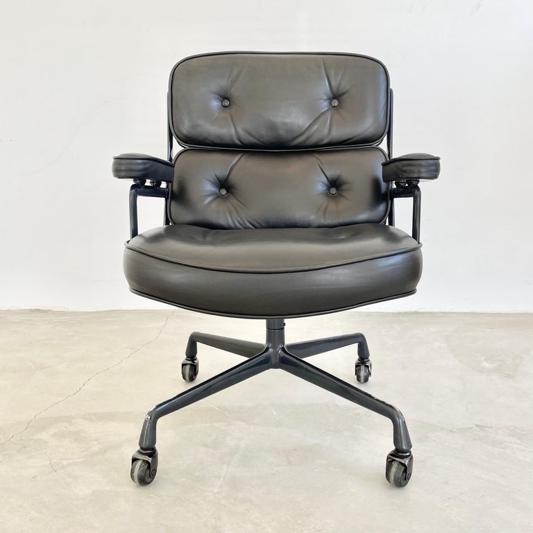 Classic Eames Time Life swivel chair in black leather with a dark grey powder coated aluminum frame. Incredible color and patina to leather and aluminum frame. All original with some wear as shown. Elegant red knob under the seat for adjusting