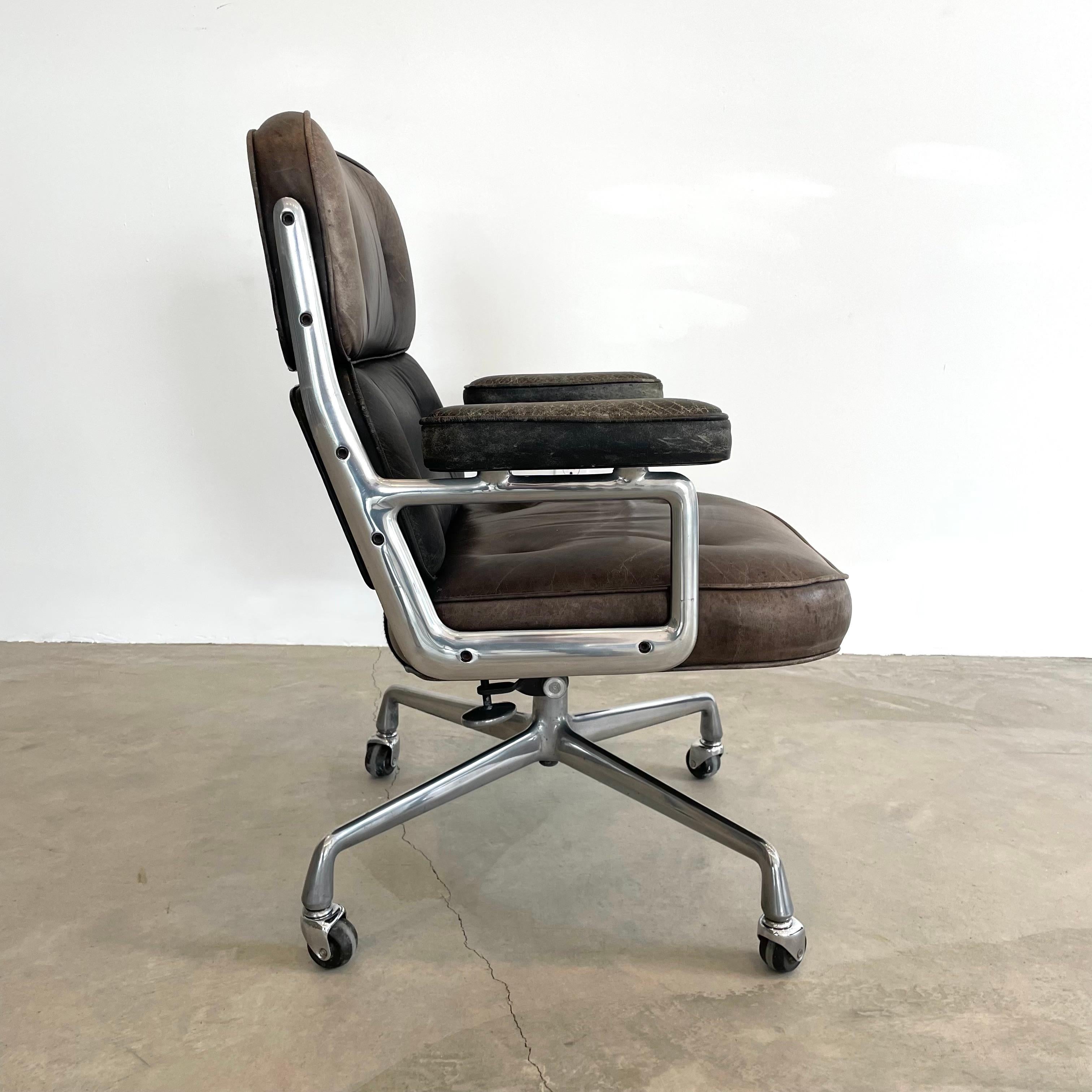 Classic Eames Time Life swivel chair in brown and black leather for Herman Miller. Original two tone chair with alternating brown and black leather, with wear as shown. Metal in good condition. Extremely comfortable and worn in. Chair swivels. Chair