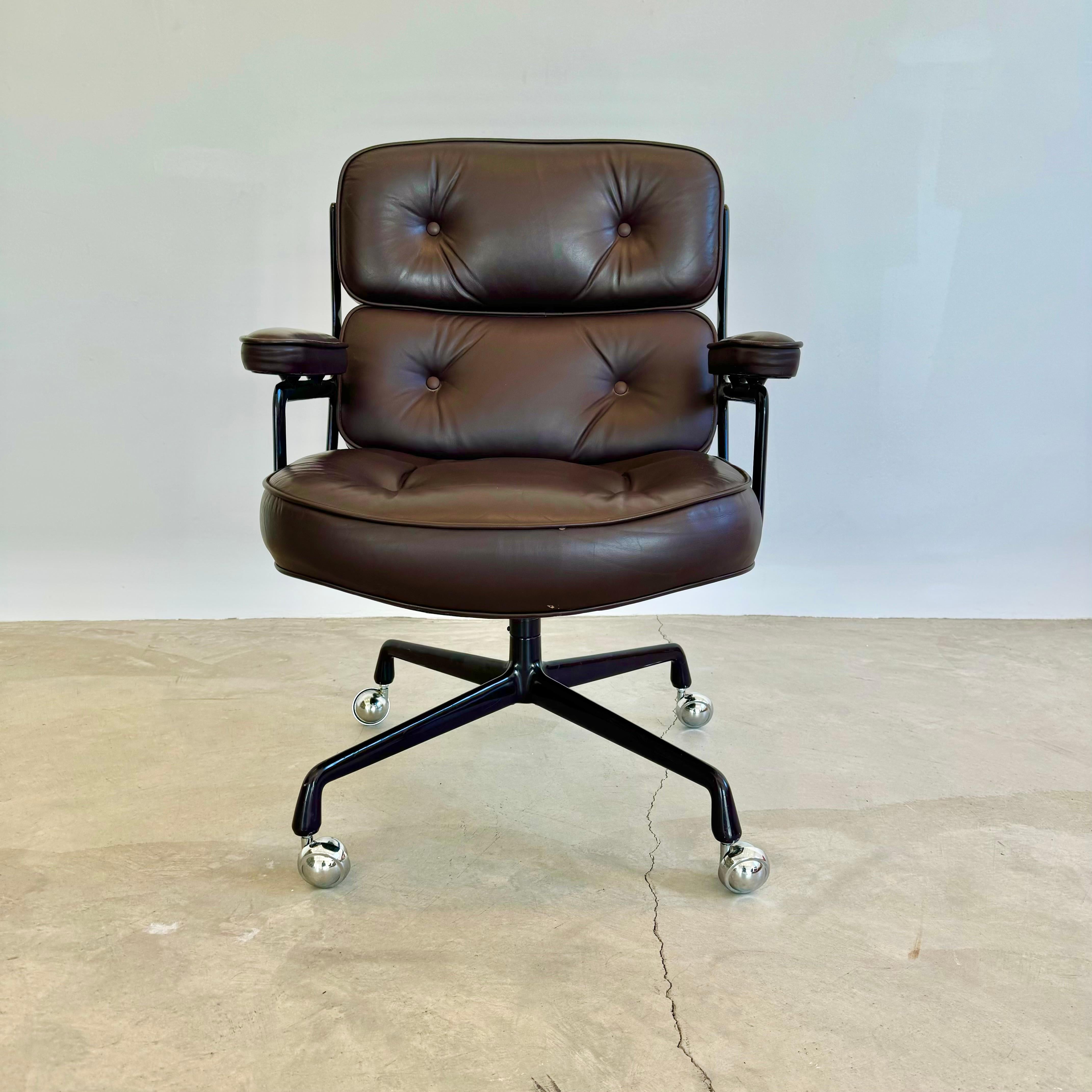 Classic Eames Time Life swivel chair in Eggplant leather with a dark purple powder coated aluminum frame. Incredible color and condition to leather and aluminum frame. All original with some wear as shown. Elegant red knob under the seat for