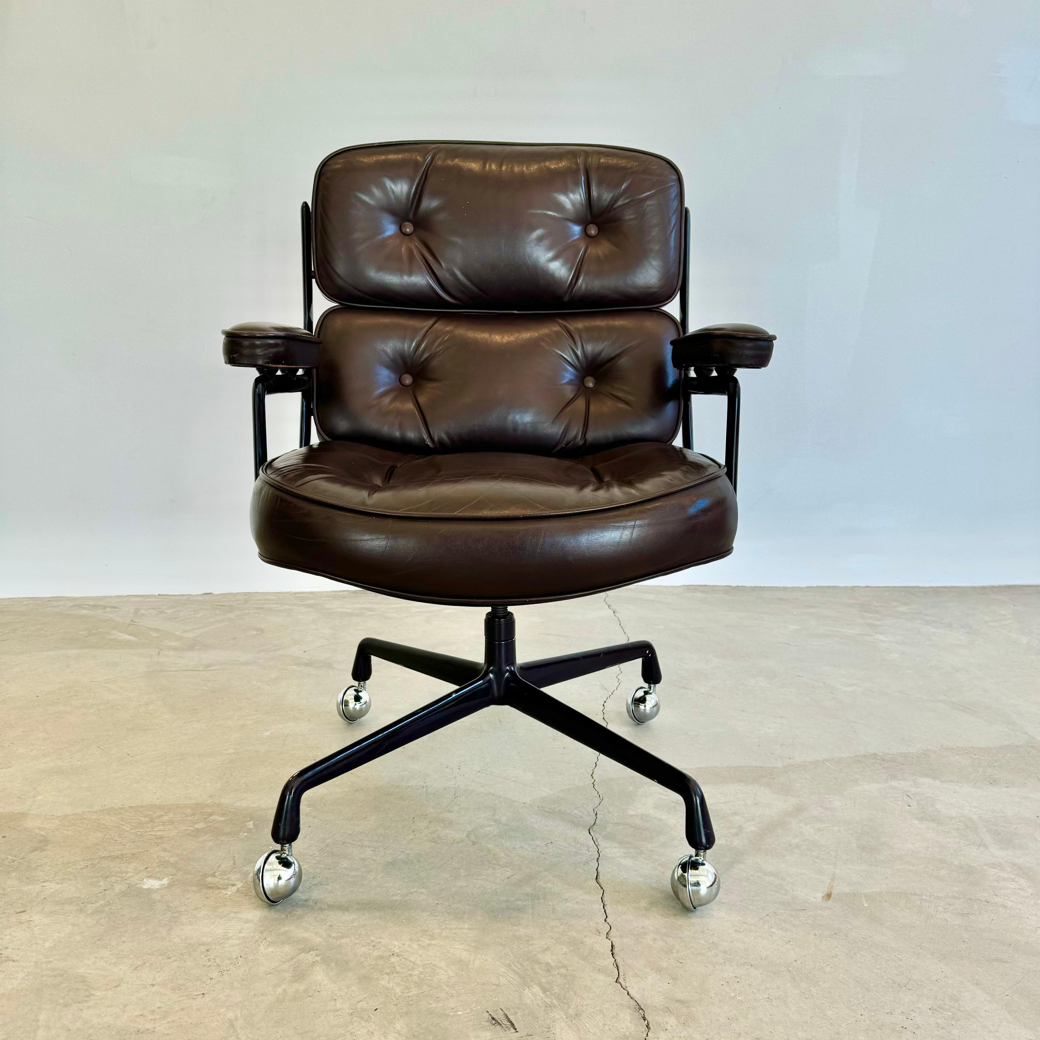 Classic Eames Time Life swivel chair in a dark eggplant colored leather for Herman Miller. Original leather with wear as shown. Matching powder coated frame in a dark eggplant color. Extremely comfortable and worn in. Chair swivels. Chair reclines.