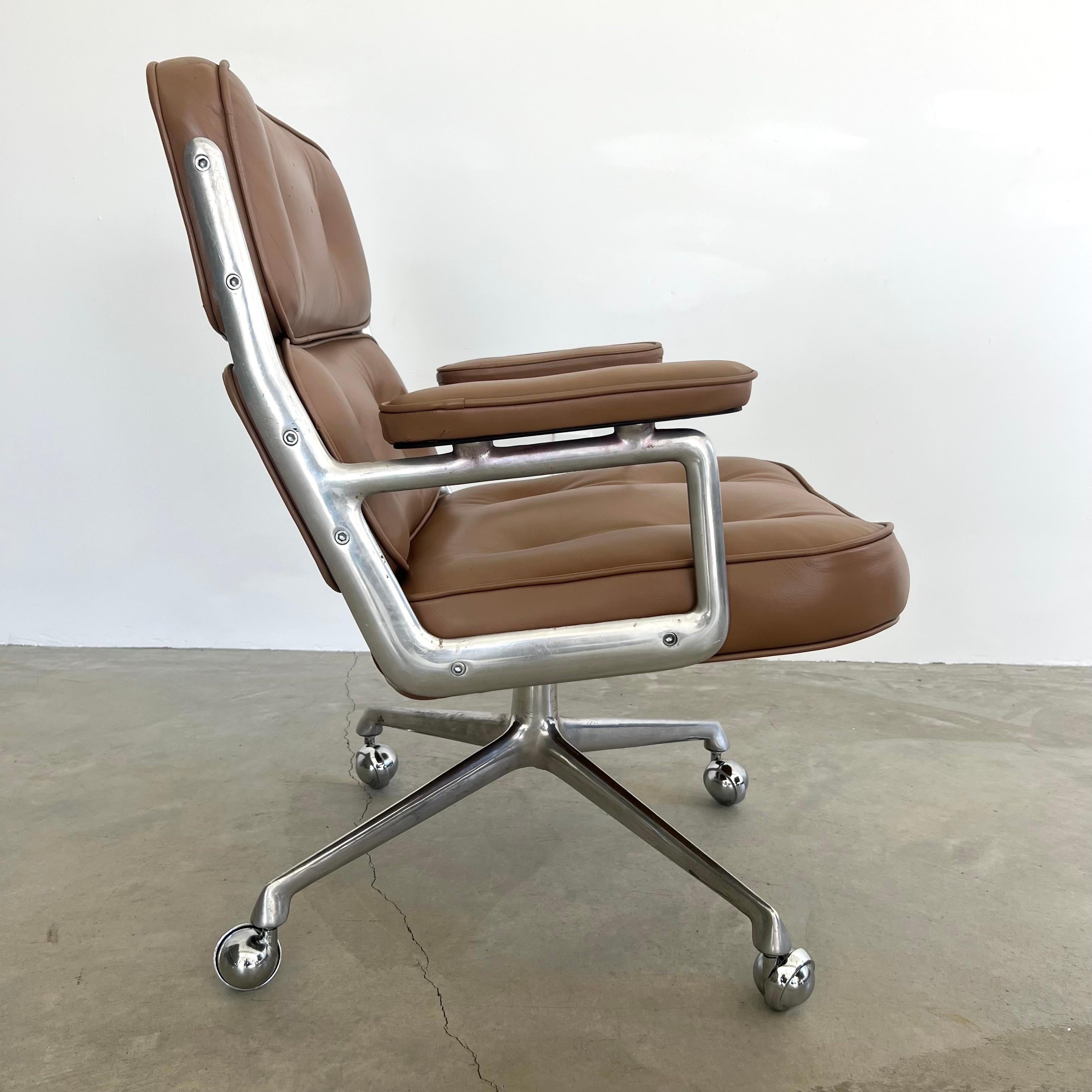 Chaise classique Eames Time Life pour Herman Miller en cuir fauve avec un cadre et des pieds en aluminium poli. Conçu à l'origine en 1960 par Charles et Ray Eames pour le hall d'entrée de l'immeuble Time Life à New York. 

Récemment nettoyé et le