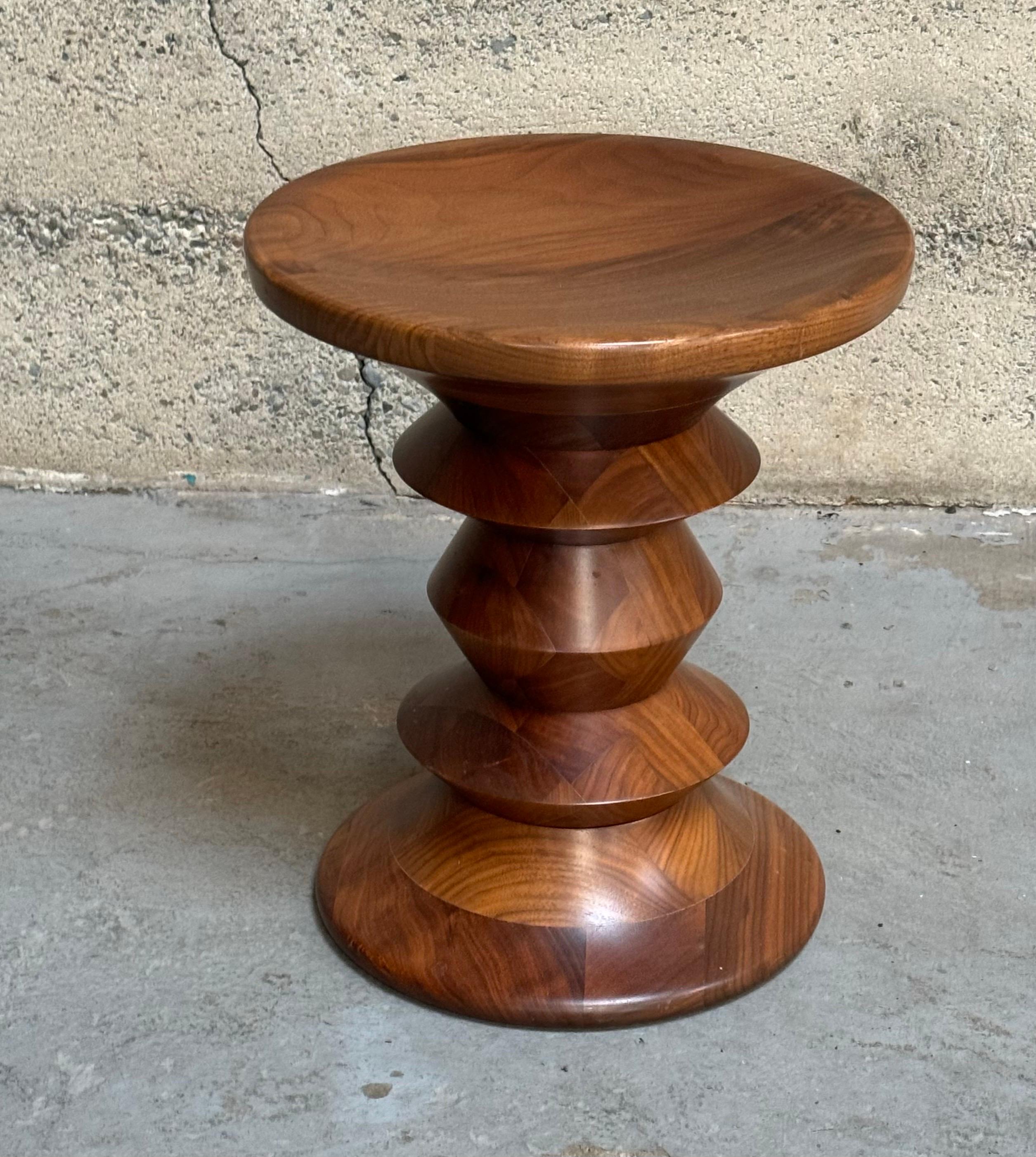 Times Life stool model C designed by Ray and Charles Eames for the Time Life Building during the 1950s, crafted from turned solid walnut. These are newer production pieces with a rich color and graining.