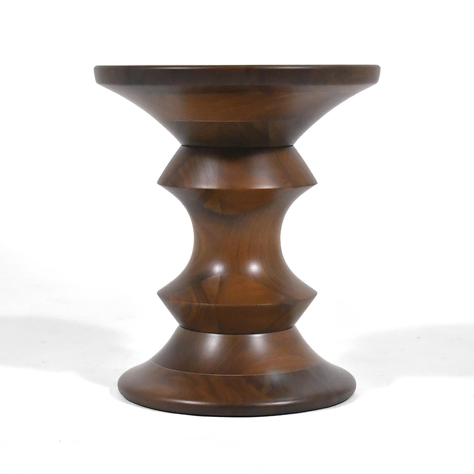This model 411 walnut stool is one of three designs which were originally created by Charles and Ray Eames for the lobby of the Time-Life building in 1961. The solid walnut forms function equally well as a stool or side table. Often reffered to as