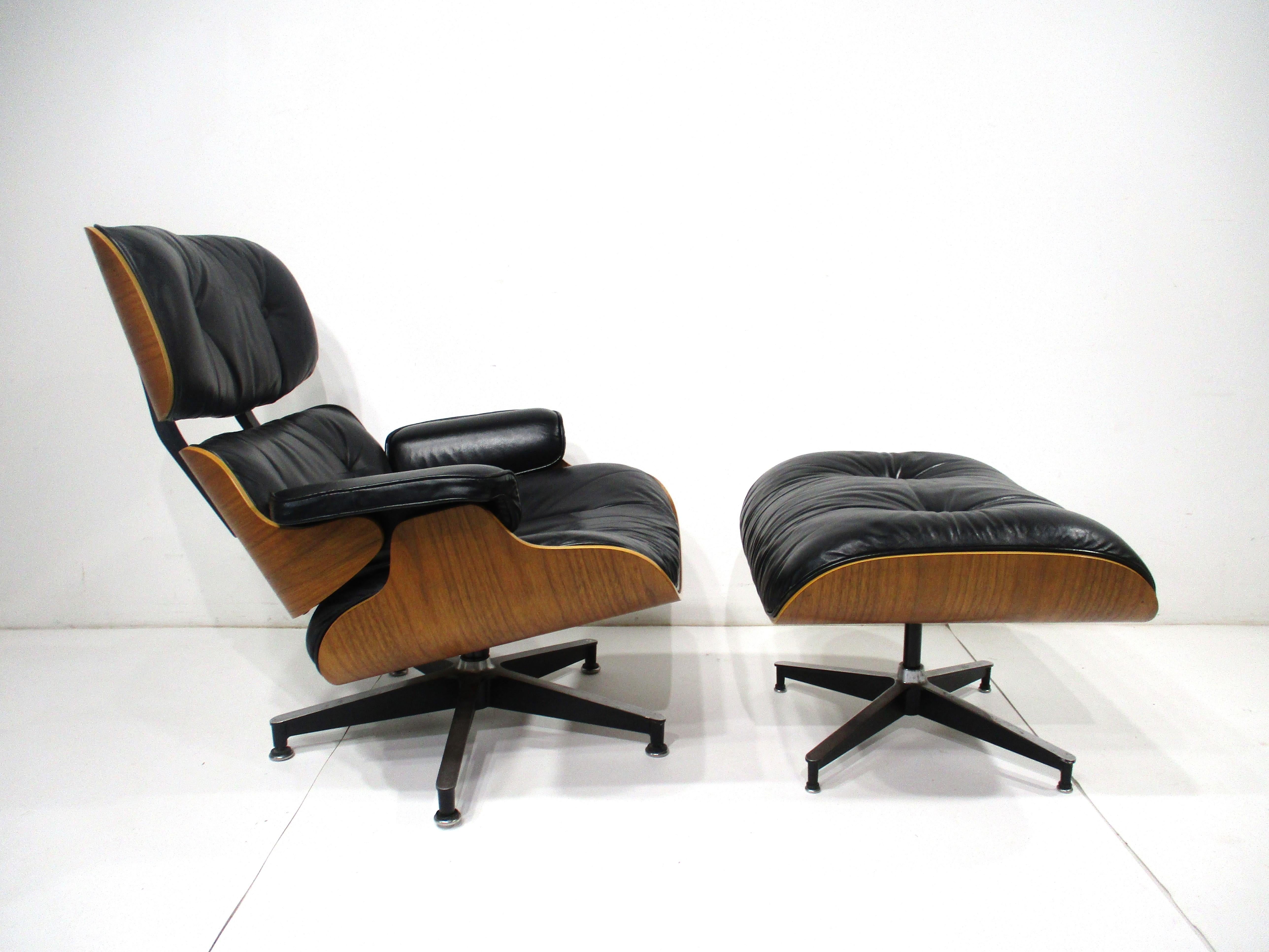 The classic iconic Eames lounge chair and ottoman with walnut frame, soft black leather upholstered cushions and cast aluminum legs. Retains the manufactures tags to each piece by the Herman Miller furniture company , measurement for the ottoman is