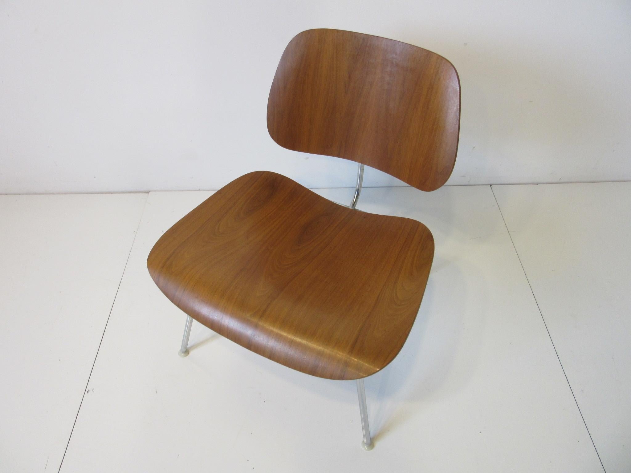 An iconic simple and timeless design of bent well grained walnut on a chrome frame with nylon feet. Retains the original manufactures label by the Herman Miller furniture company.