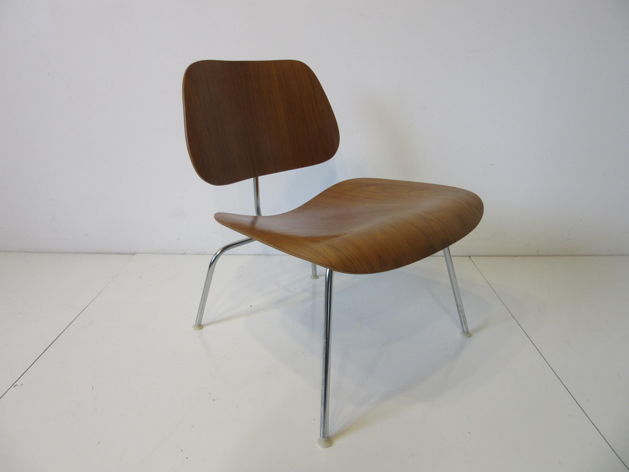 A well grained bent walnut ply LCM (Lounge Chair Metal) chair with nylon foot pads retaining the original manufactures labels from the Herman Miller furniture company. An iconic design with a timeless design that works with any interior.