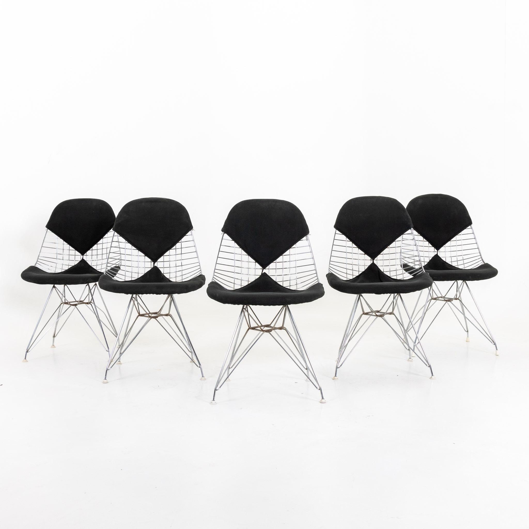 Set of five DKR-2 Eames Wire chairs with black bikini upholstery on Eiffel Tower frame. Signs of age and use.