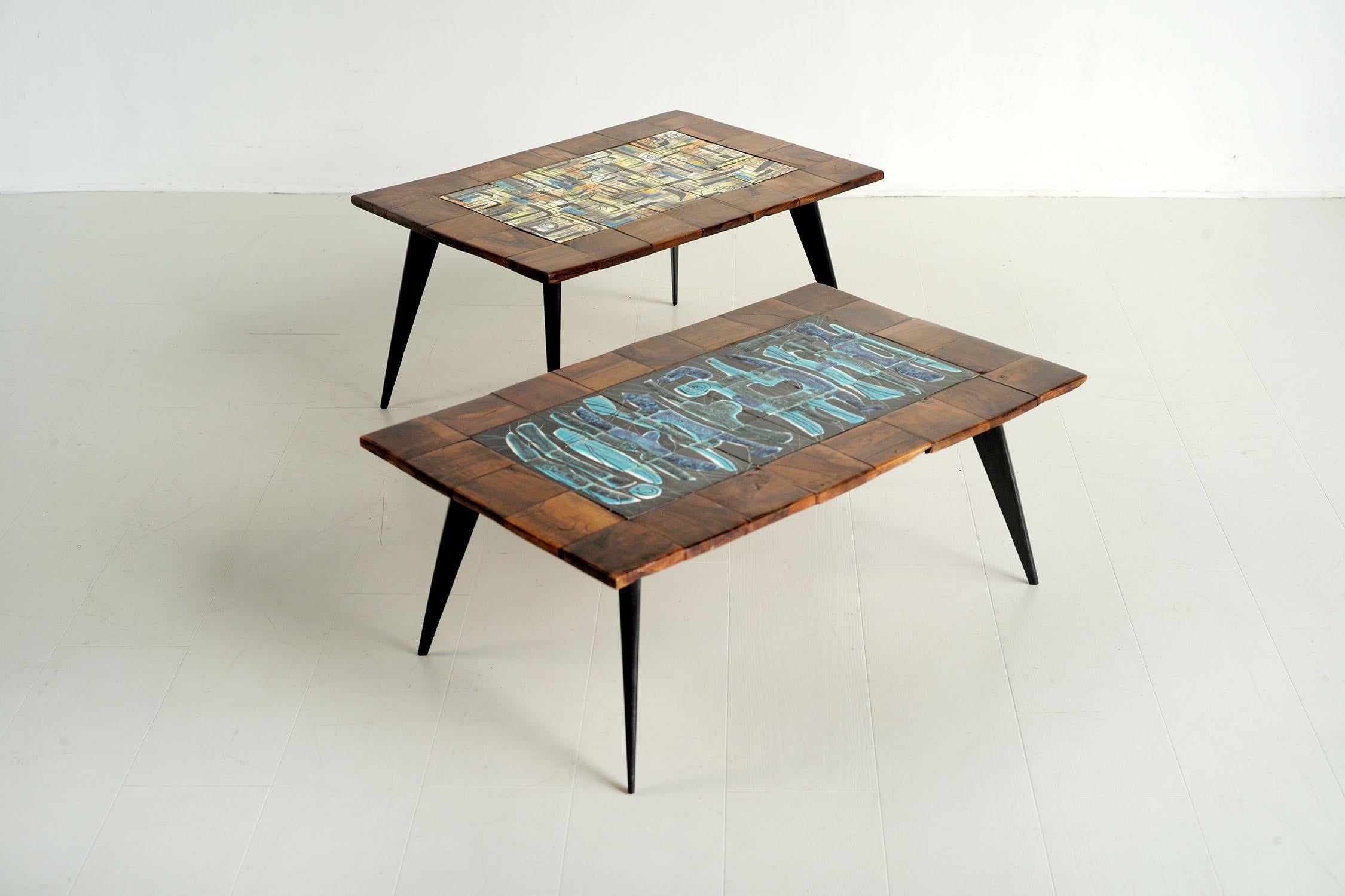 Unique pair of coffee tables by Jean de Lespinasse, France 1950. This duo of tables comes in two versions. The larger one features a fresco in shades of blue, the second in a dominant yellow. Both are framed with olive tiles, resting on folded and