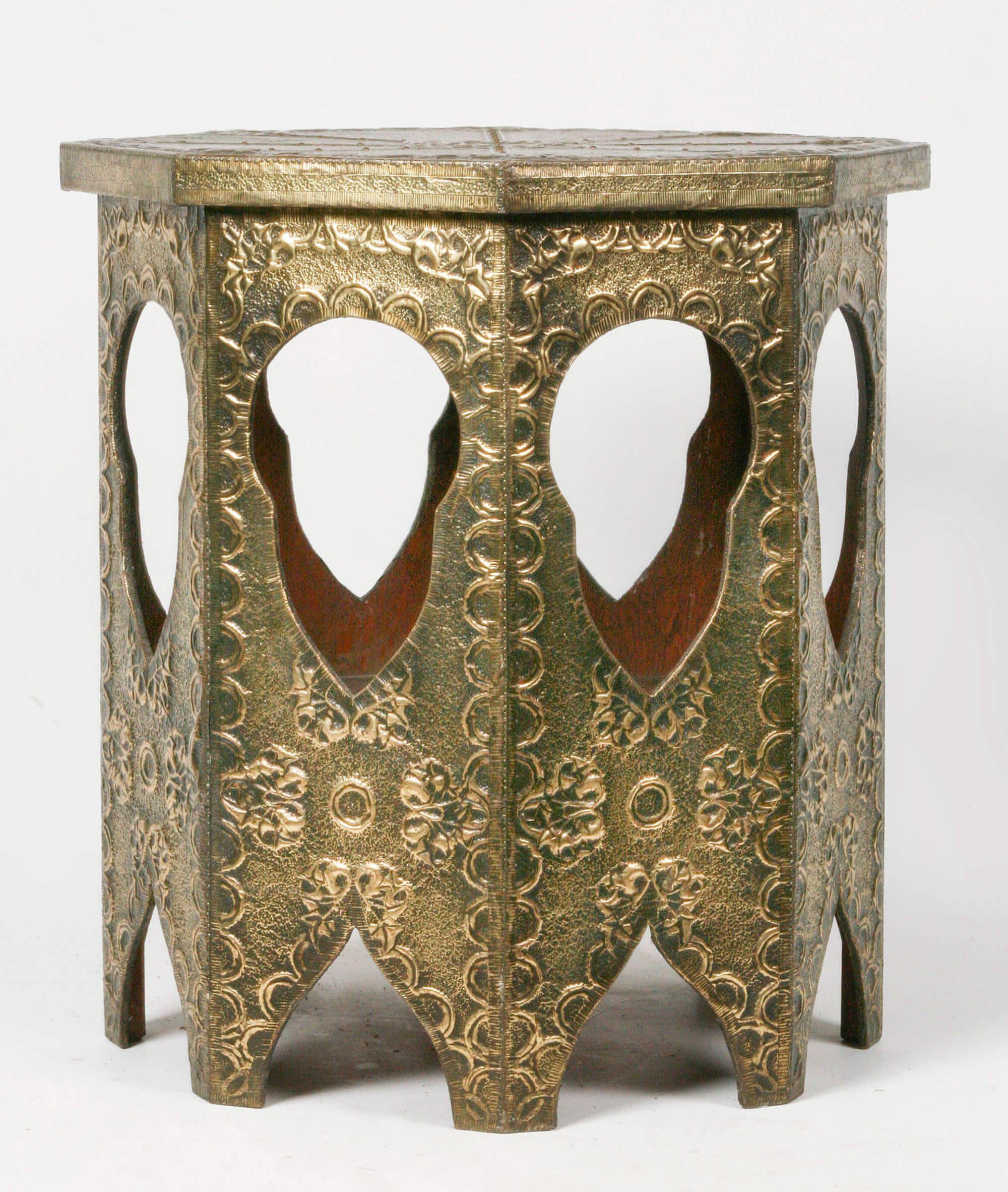 A French coffee table in Art Deco style. Yellow embossed laton copper, nailed on a wooden base. The table have eight sides, on each side an opening in eastern style. Made in France, circa 1920-1930.